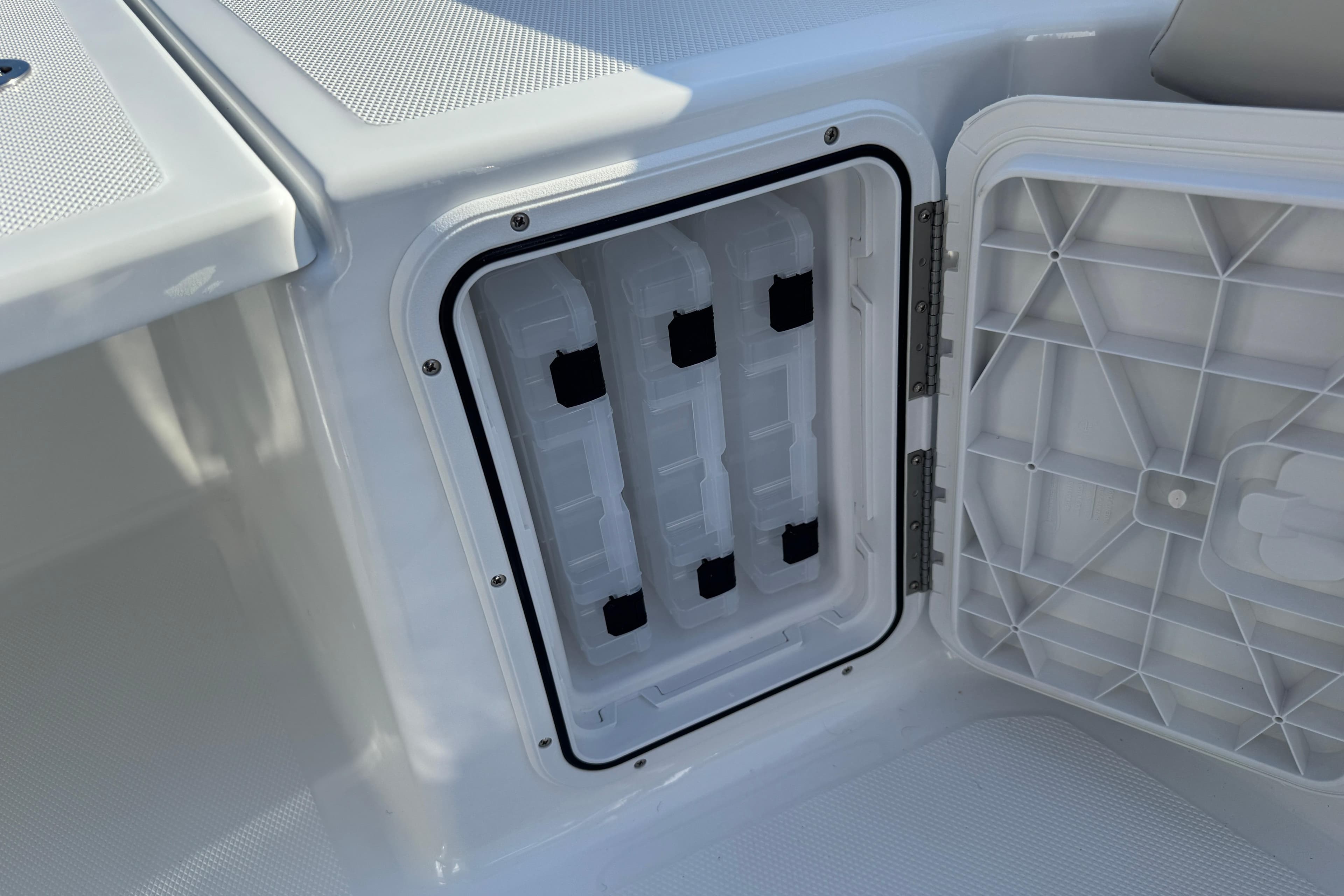 Open storage compartment on 2026 Scarab 235 Open SE boat, showcasing interior design.