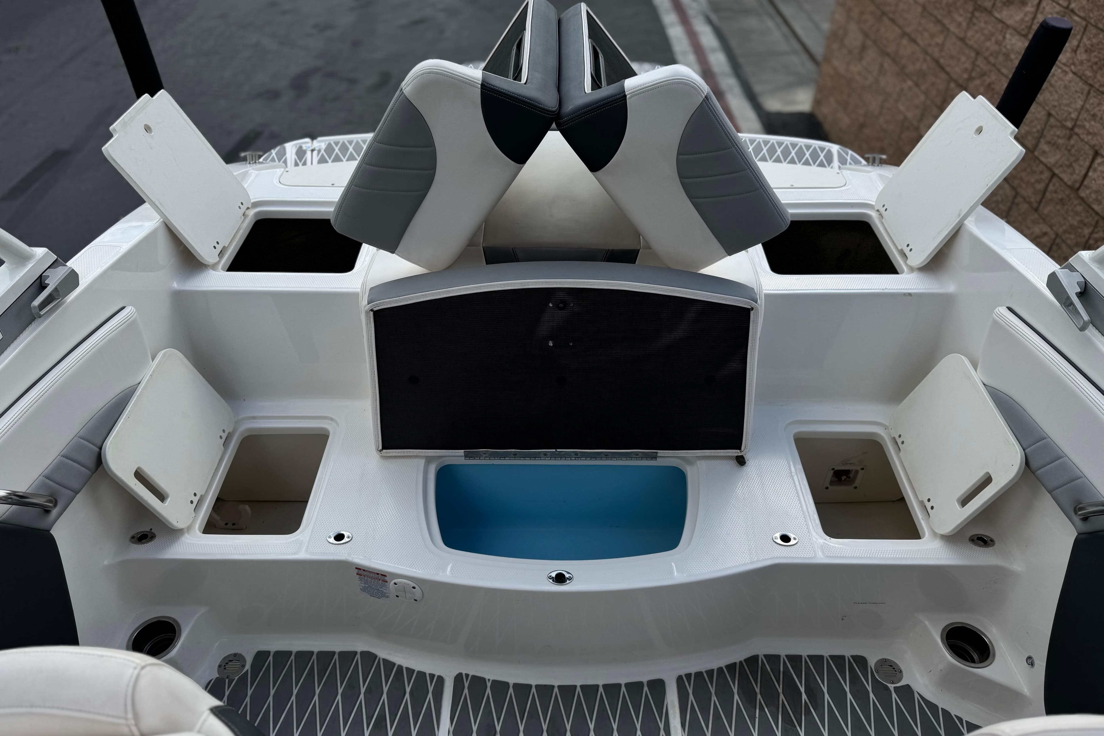 2020 Chaparral 21 Surf boat interior with open storage compartments and seating.