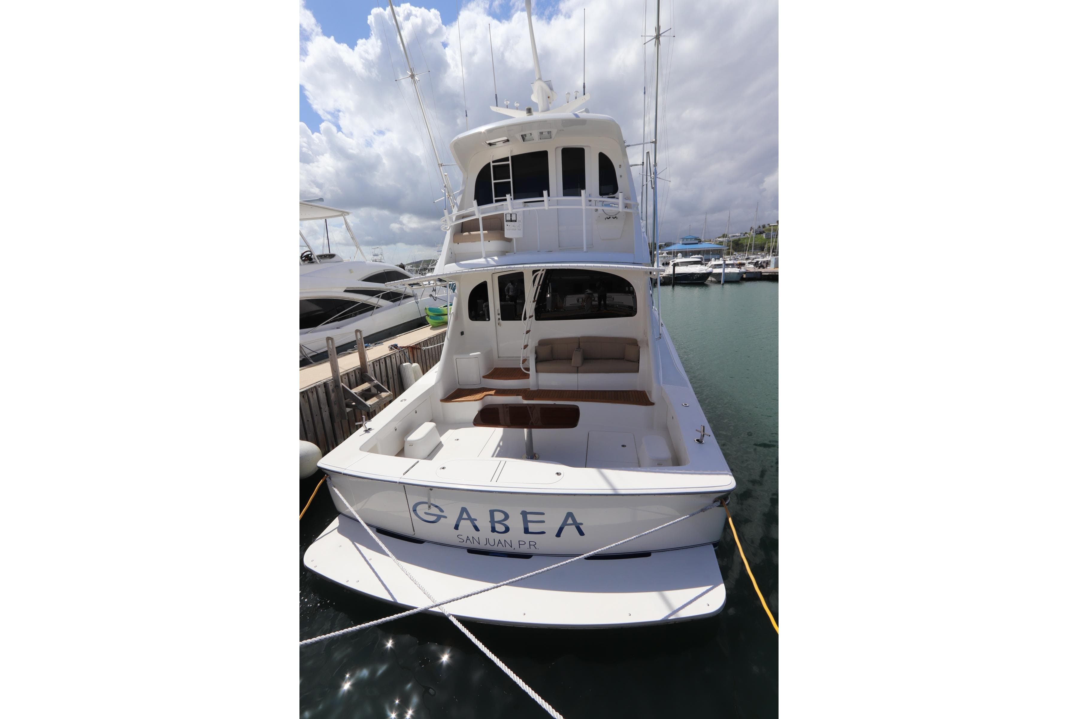 2013 Viking 66 yacht docked in marina, rear view with clear skies.