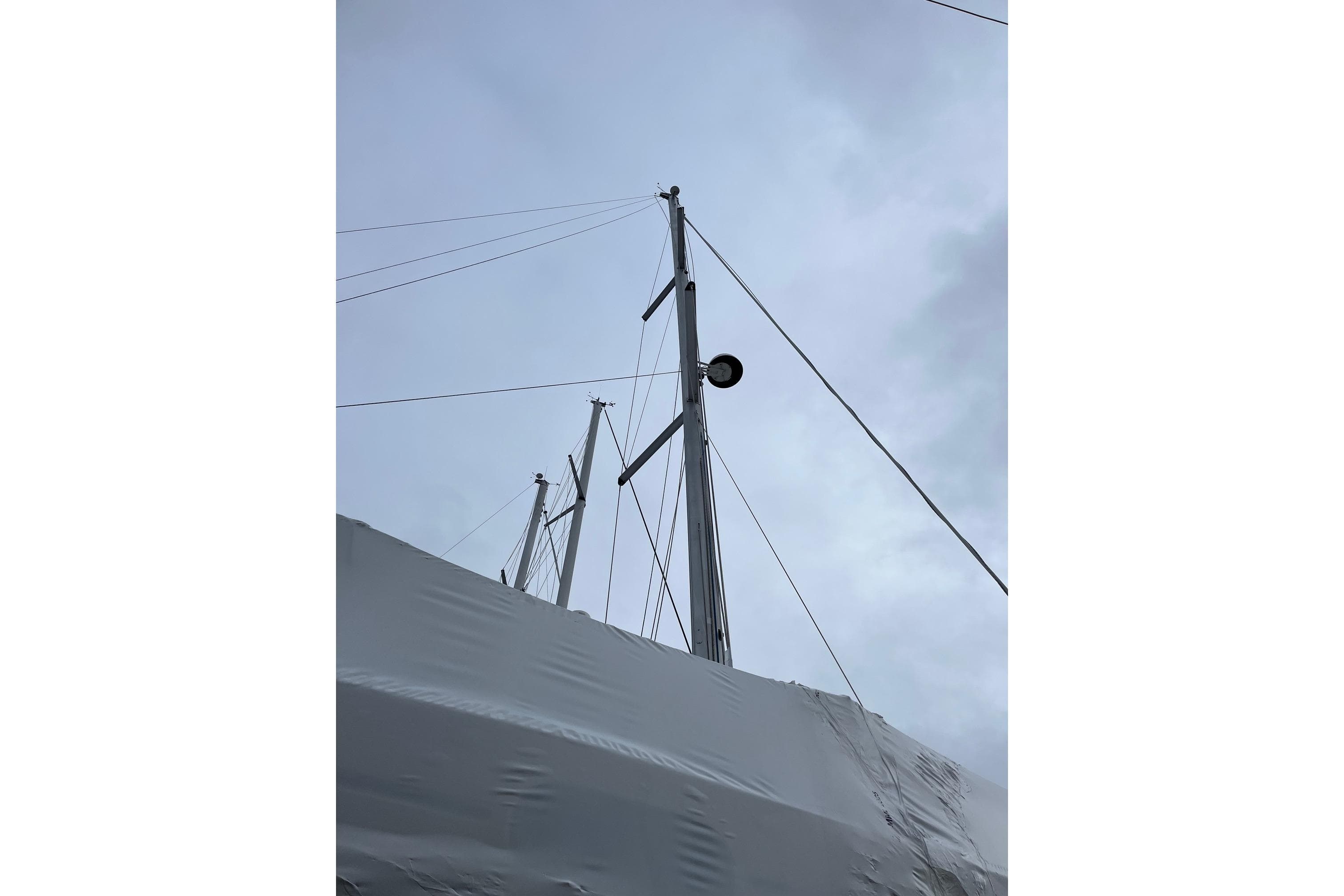 Masts of a 2008 Jeanneau Sun Odyssey 45 sailboat against a cloudy sky.