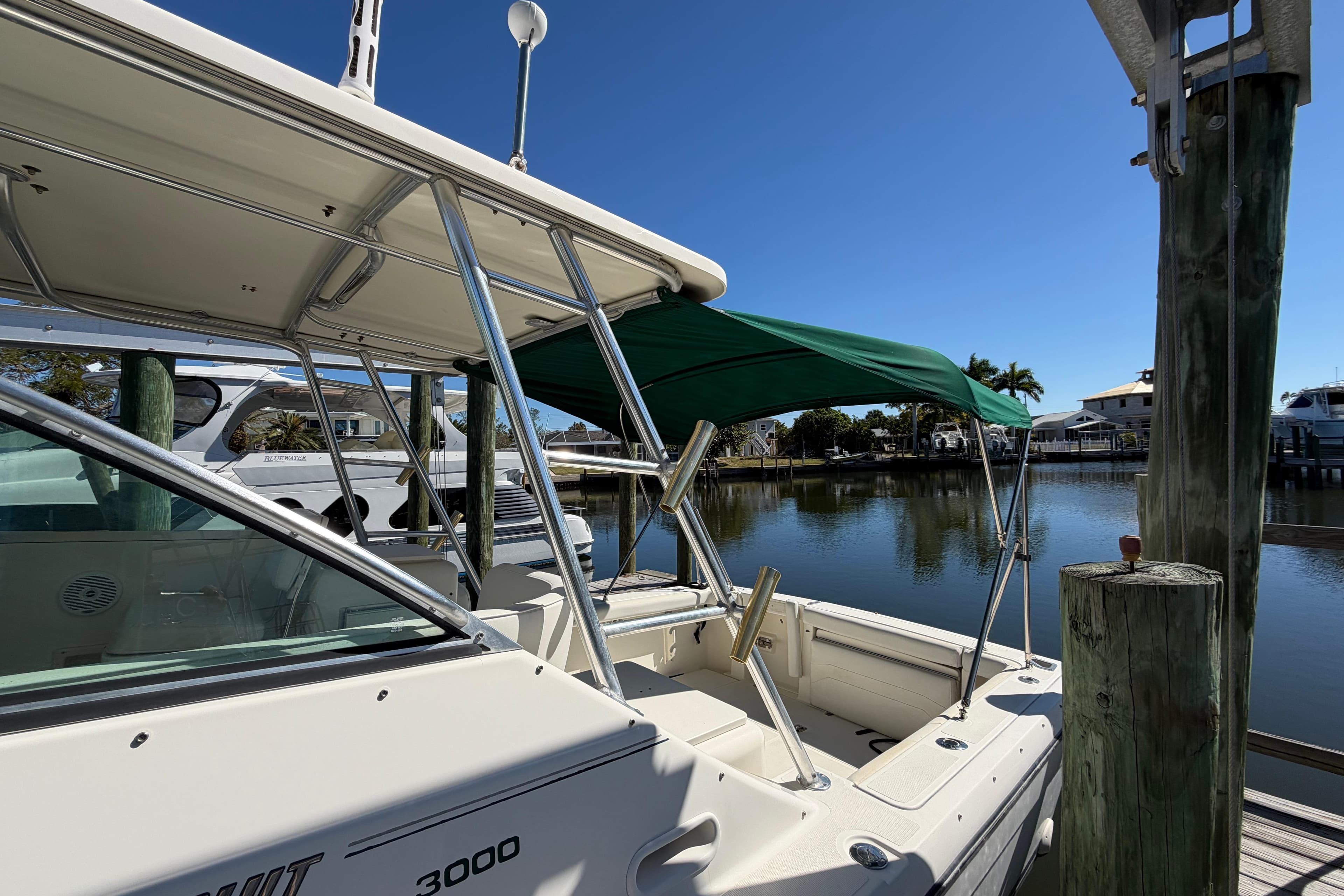 2001 Pursuit 3000 Express boat docked by calm waters under clear blue sky.
