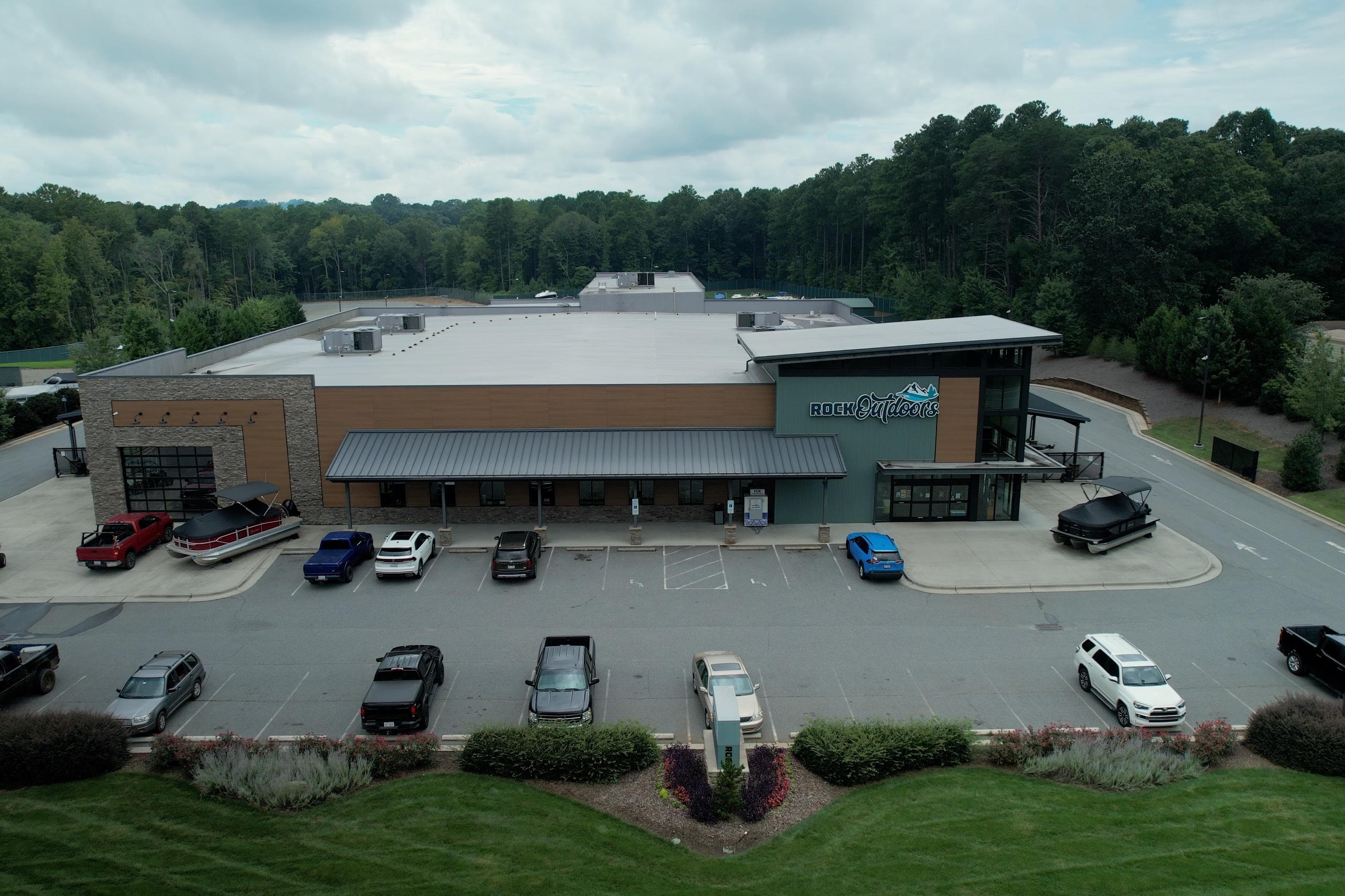 Aerial view of Rock Outdoors store with parked vehicles, including a G3 Gator Tough 18 CCJ boat.