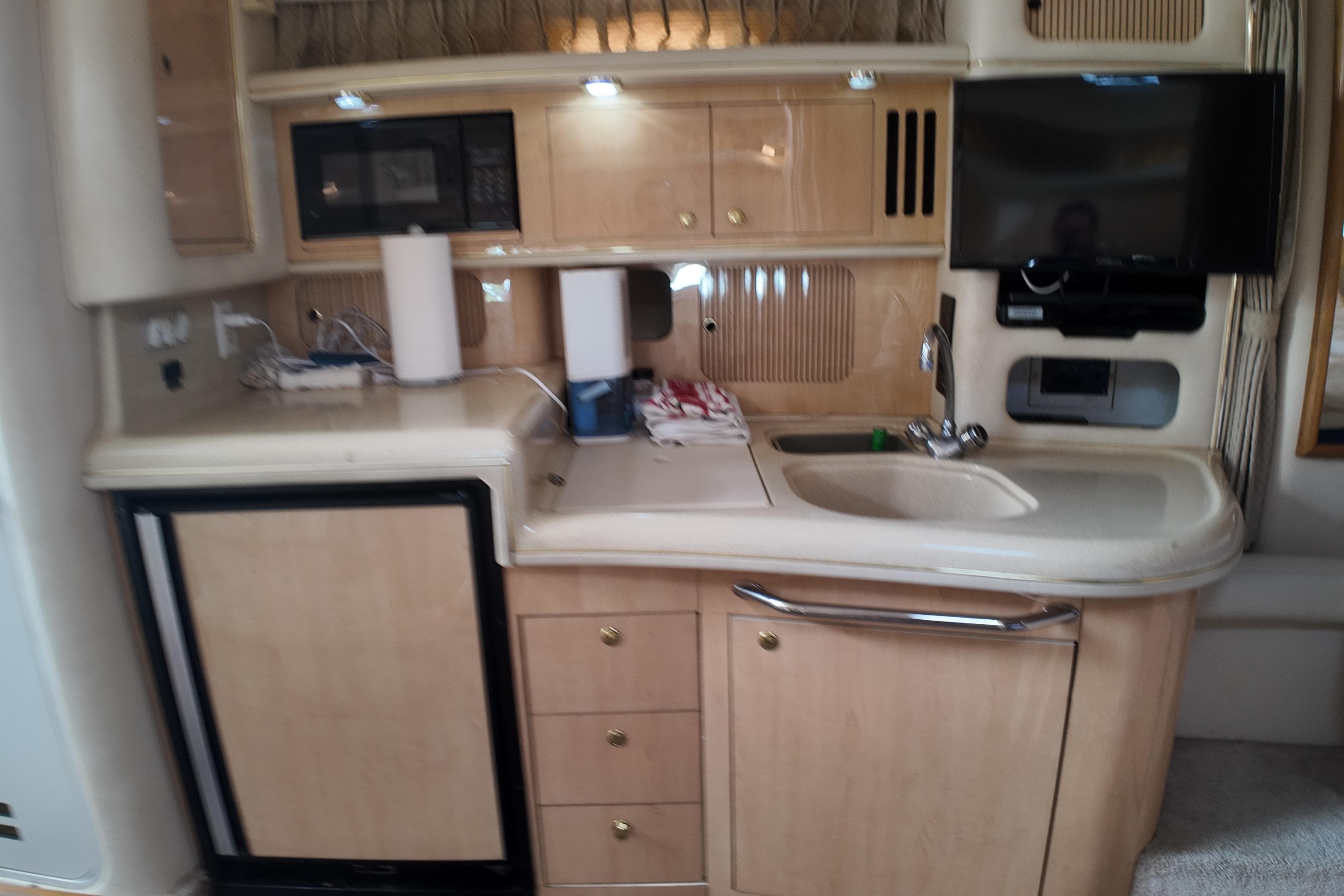 1999 Sea Ray 340 yacht interior kitchen with sink, cabinets, and appliances.
