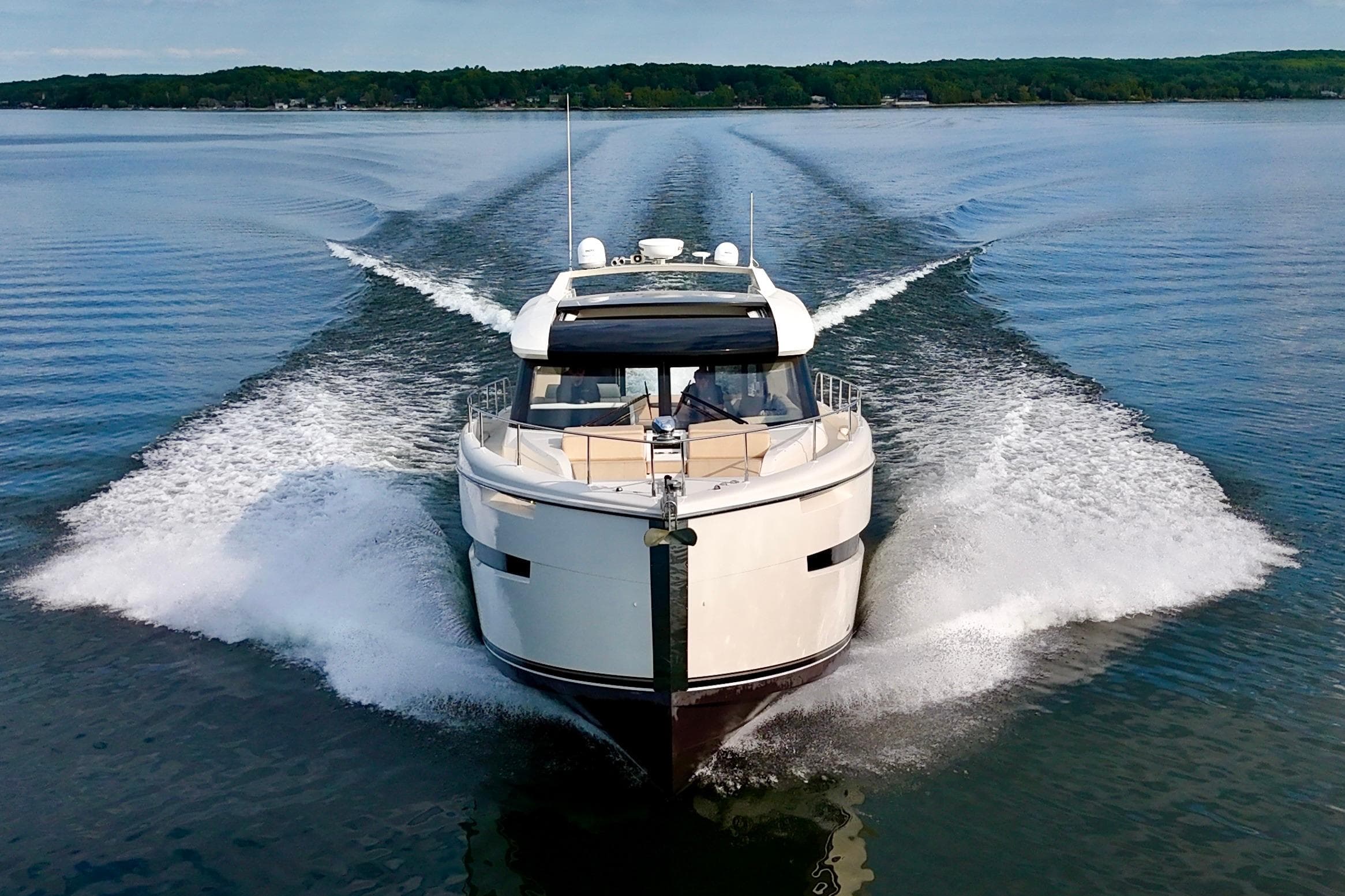 2018 Carver C52 Coupe yacht cruising on a serene lake.
