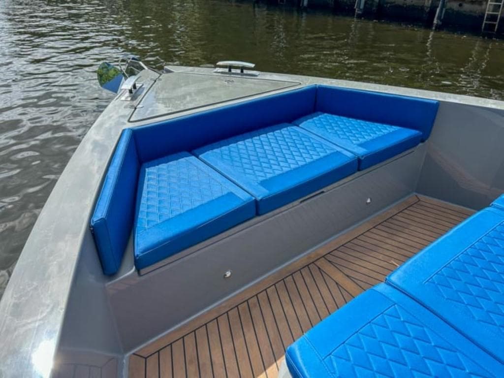 2023 De Antonio Yachts D42 Open with blue cushioned seating and teak deck.
