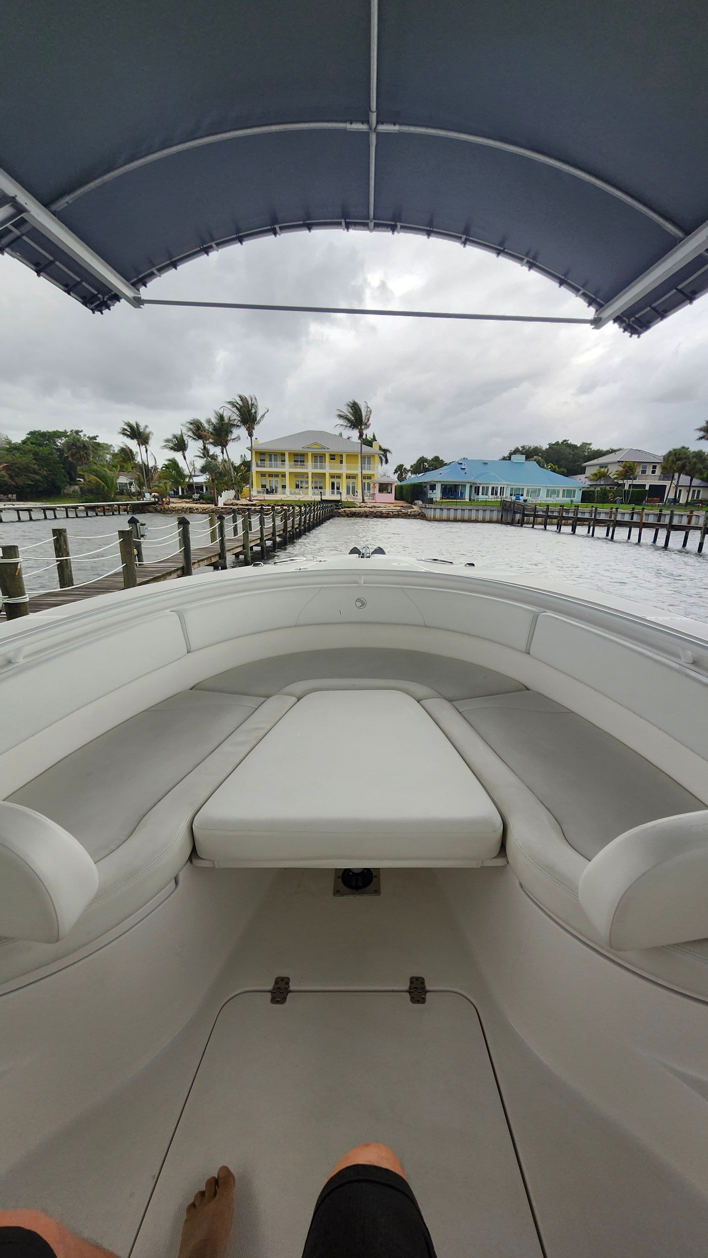 Interior view of a 2018 Edgewater 320CC boat, overlooking colorful waterfront houses.