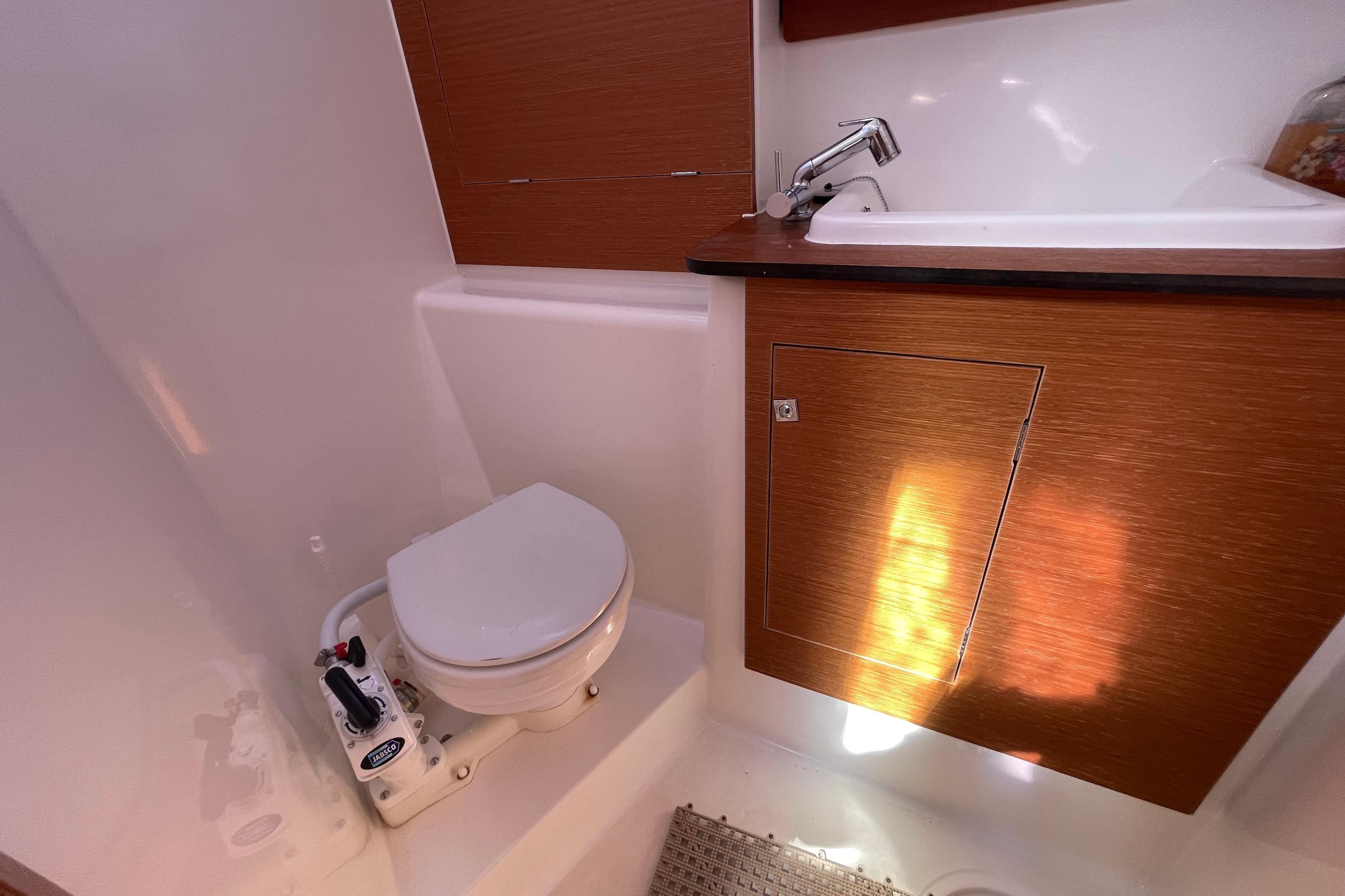 Bathroom interior of 2017 Dufour 460 Grand Large yacht, featuring toilet and sink.