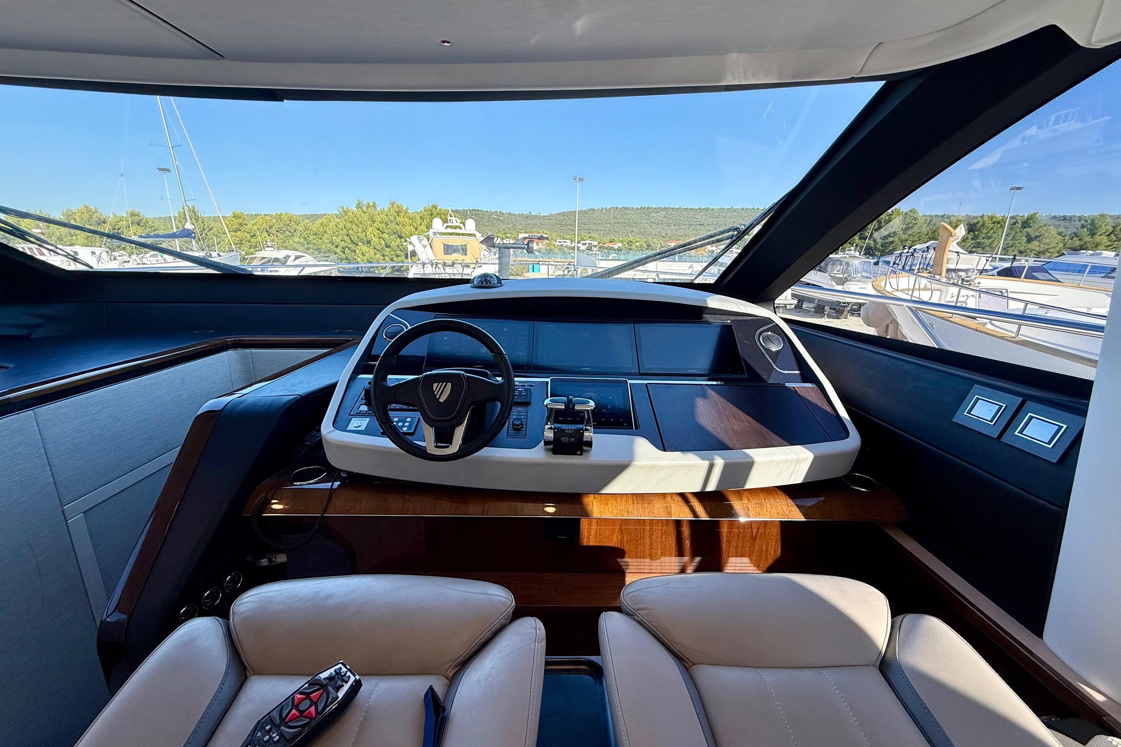 Luxurious 2022 Fairline Squadron 68 yacht cockpit with modern steering and navigation controls.