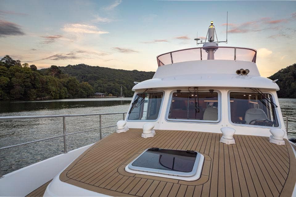Hardy Commodore 42 yacht, 2002 model, cruising on a serene river at sunset.