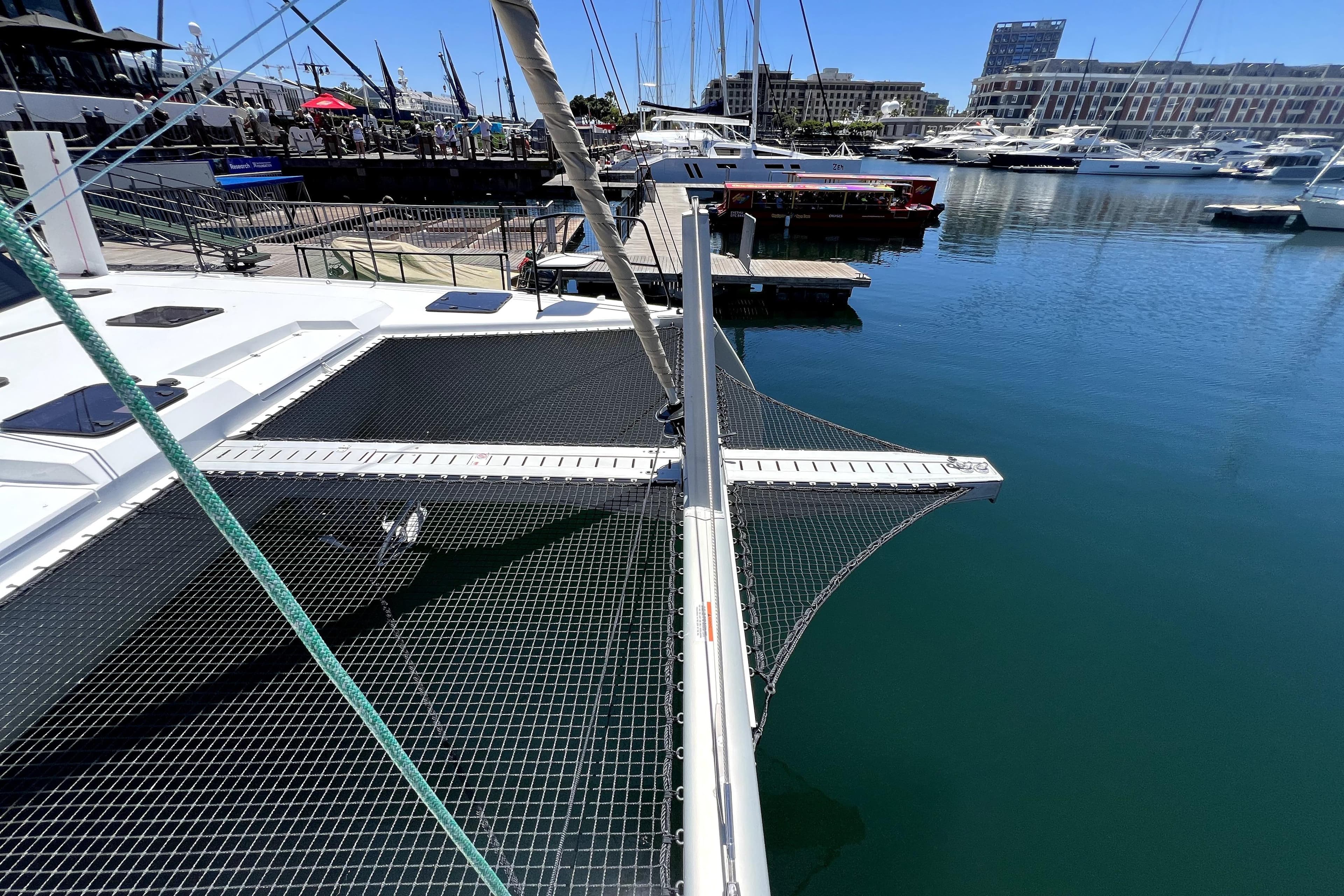 Modern Balance 482 catamaran docked at marina, showcasing netting and sleek design, 2025 model.