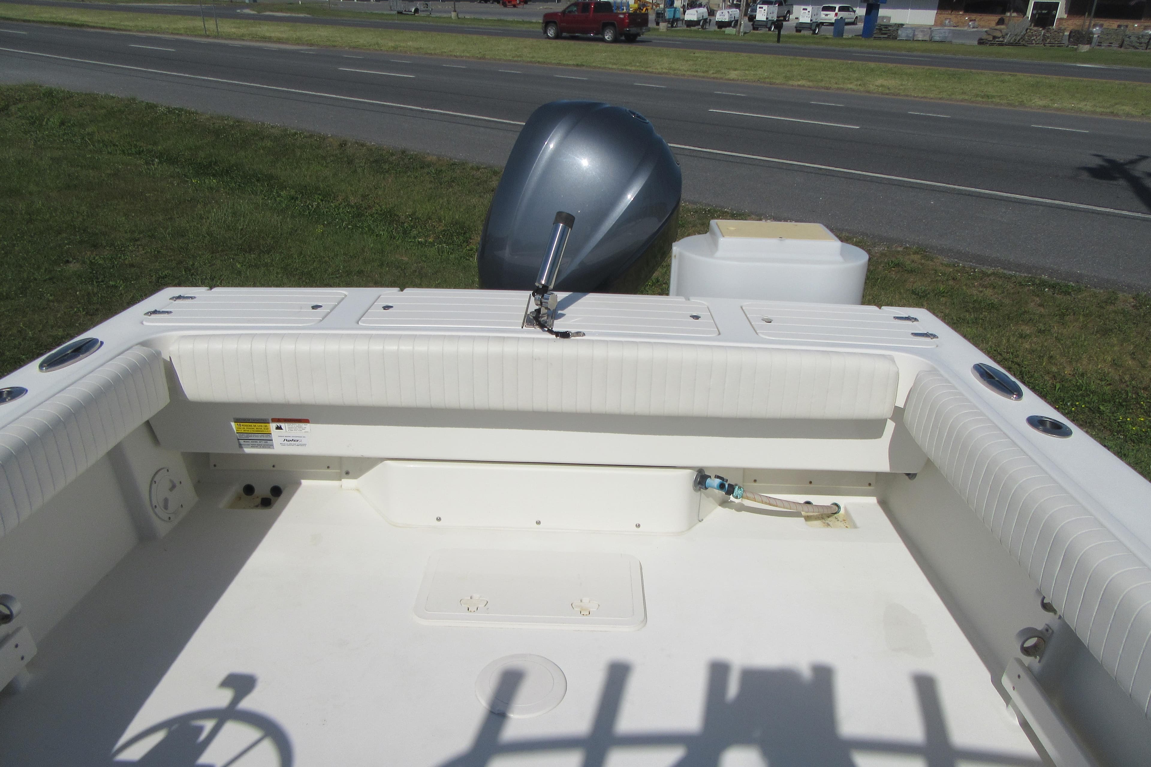 2013 Parker 2320 SL Sport Cabin boat interior with outboard motor, parked near a road.