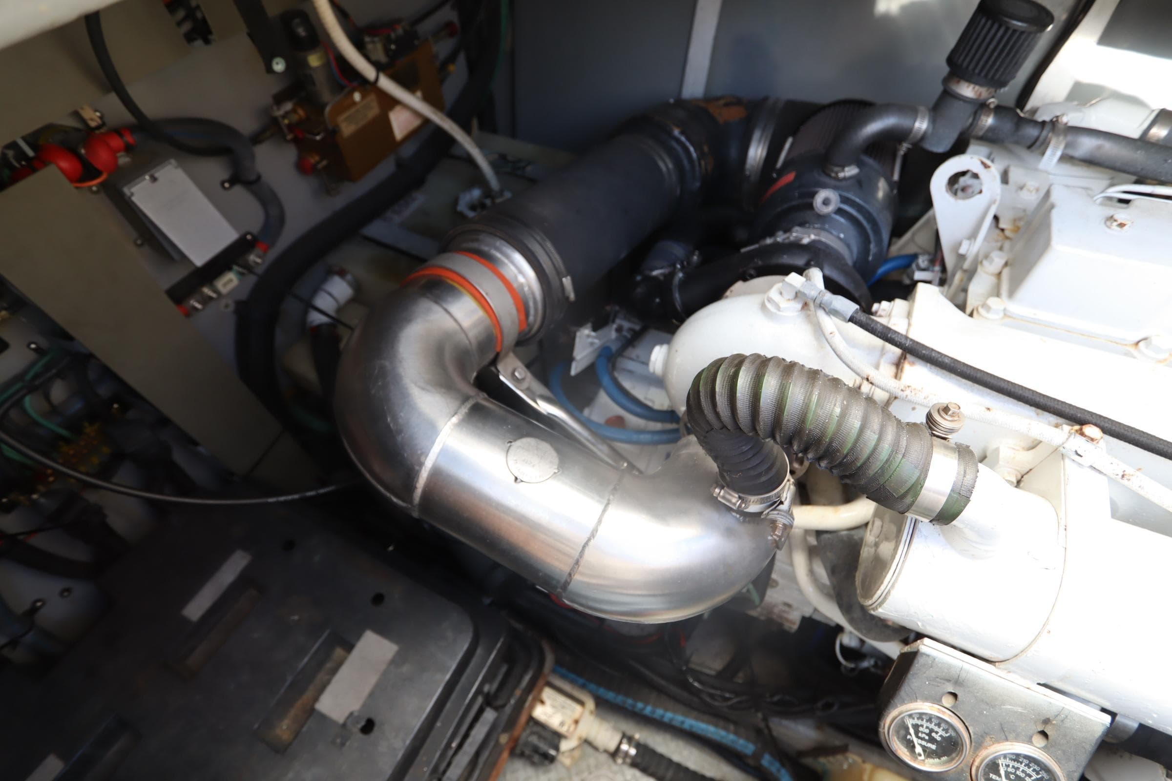 Engine compartment of a 2000 Sea Ray 460 Sundancer boat, showing pipes and gauges.