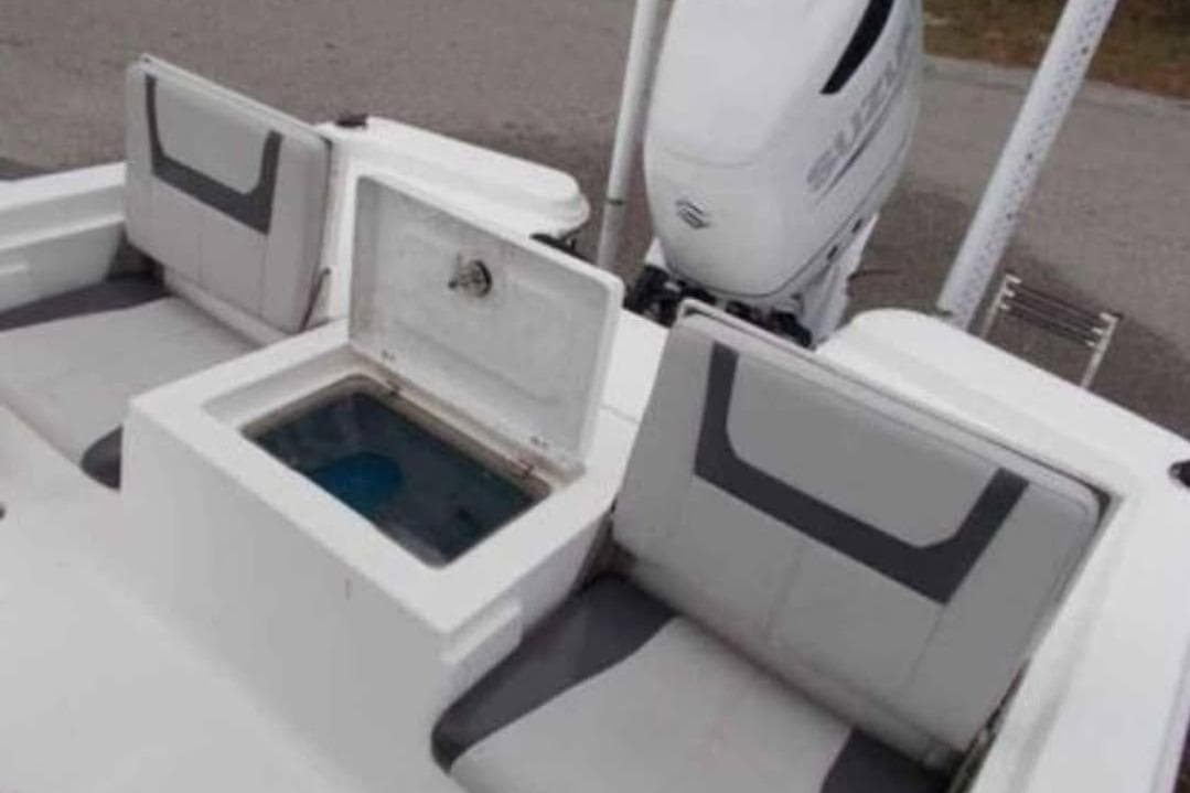 2021 Aquasport 244 Bay boat interior with seating and storage compartment.
