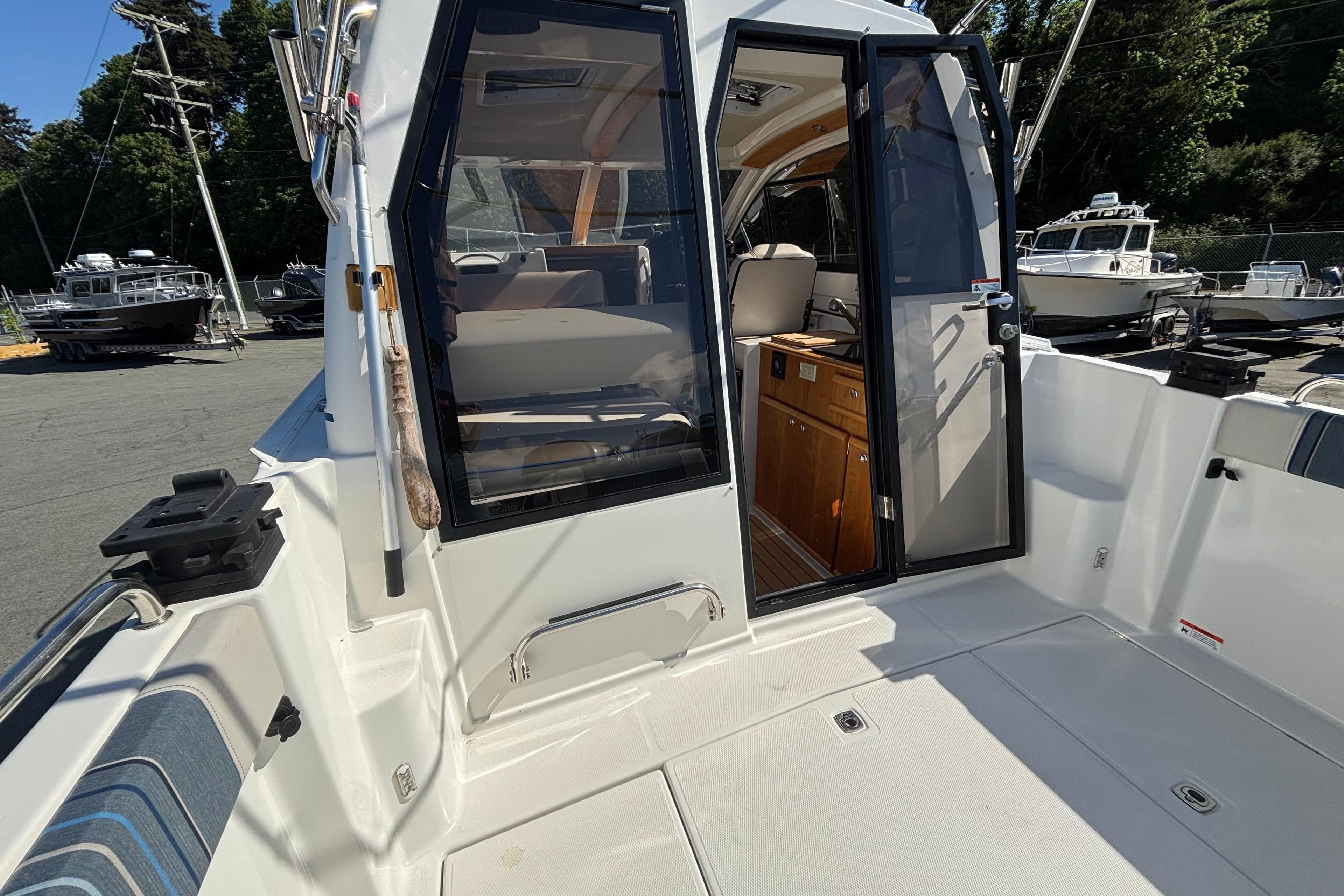 2017 Cutwater C-242 Coupe boat interior with open door, showcasing seating and cabinetry.