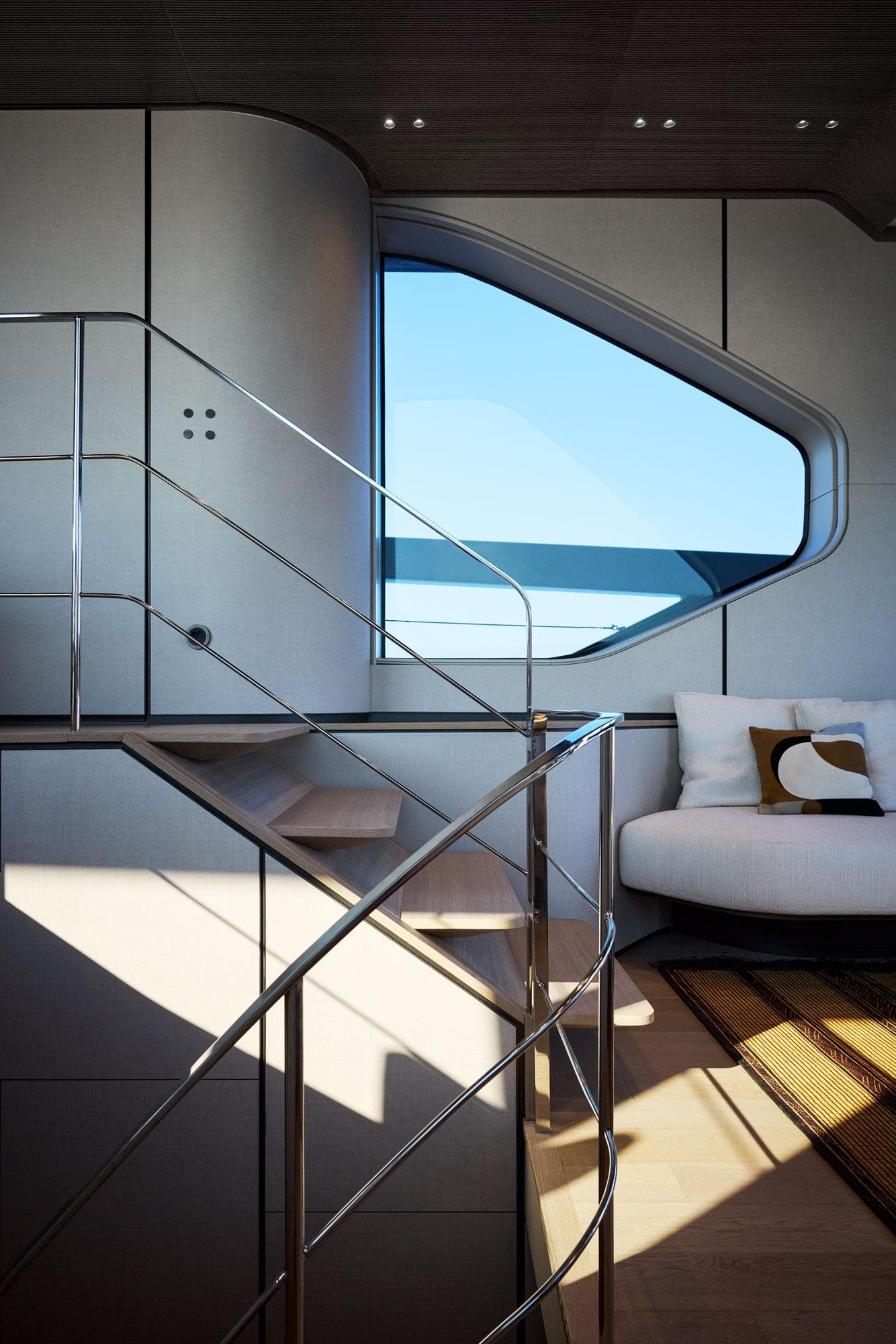 Modern interior of 2026 Sanlorenzo SP92 yacht with sleek staircase and large window.