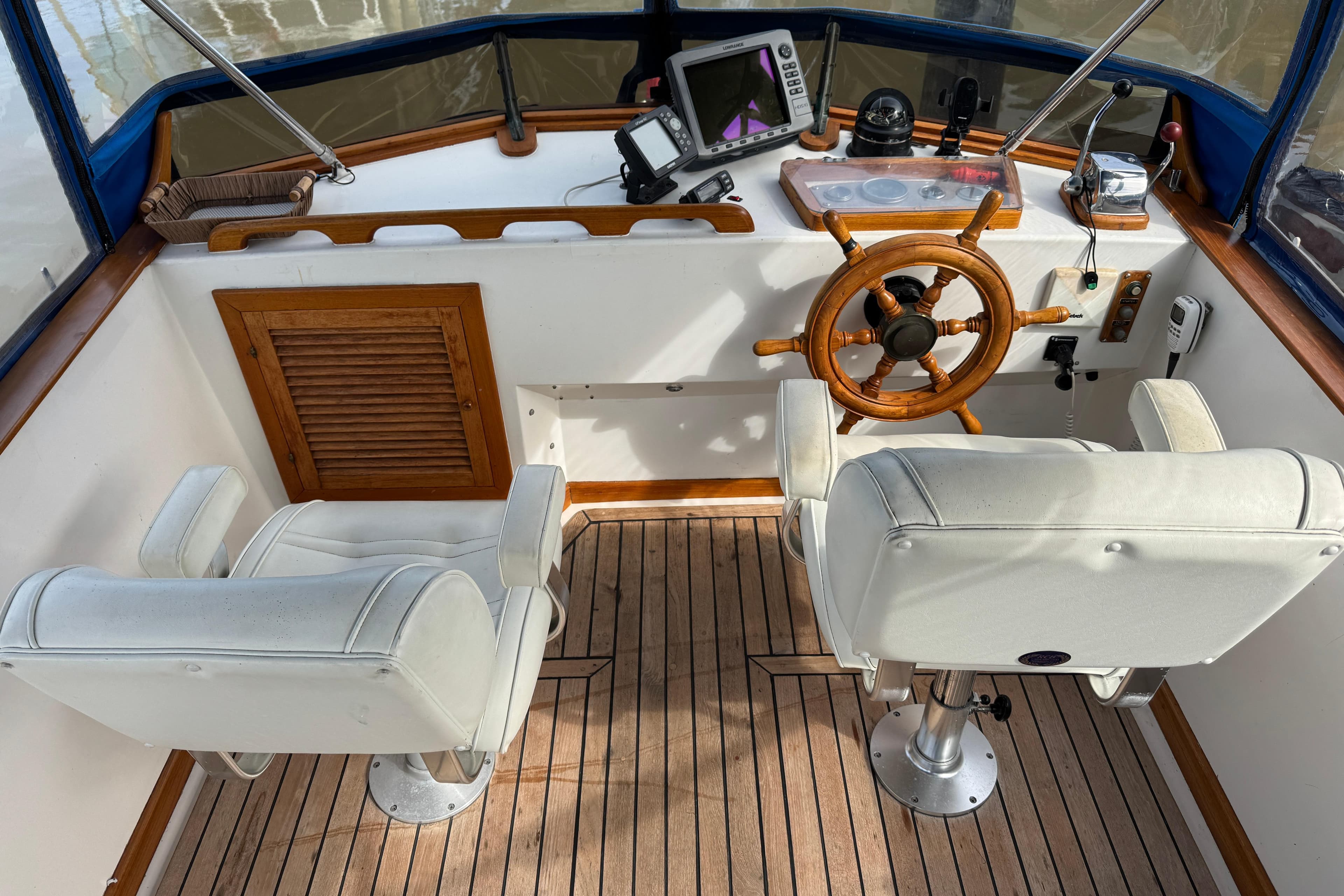 1980 CHB 35 boat helm with wooden wheel, white seats, and navigation equipment.