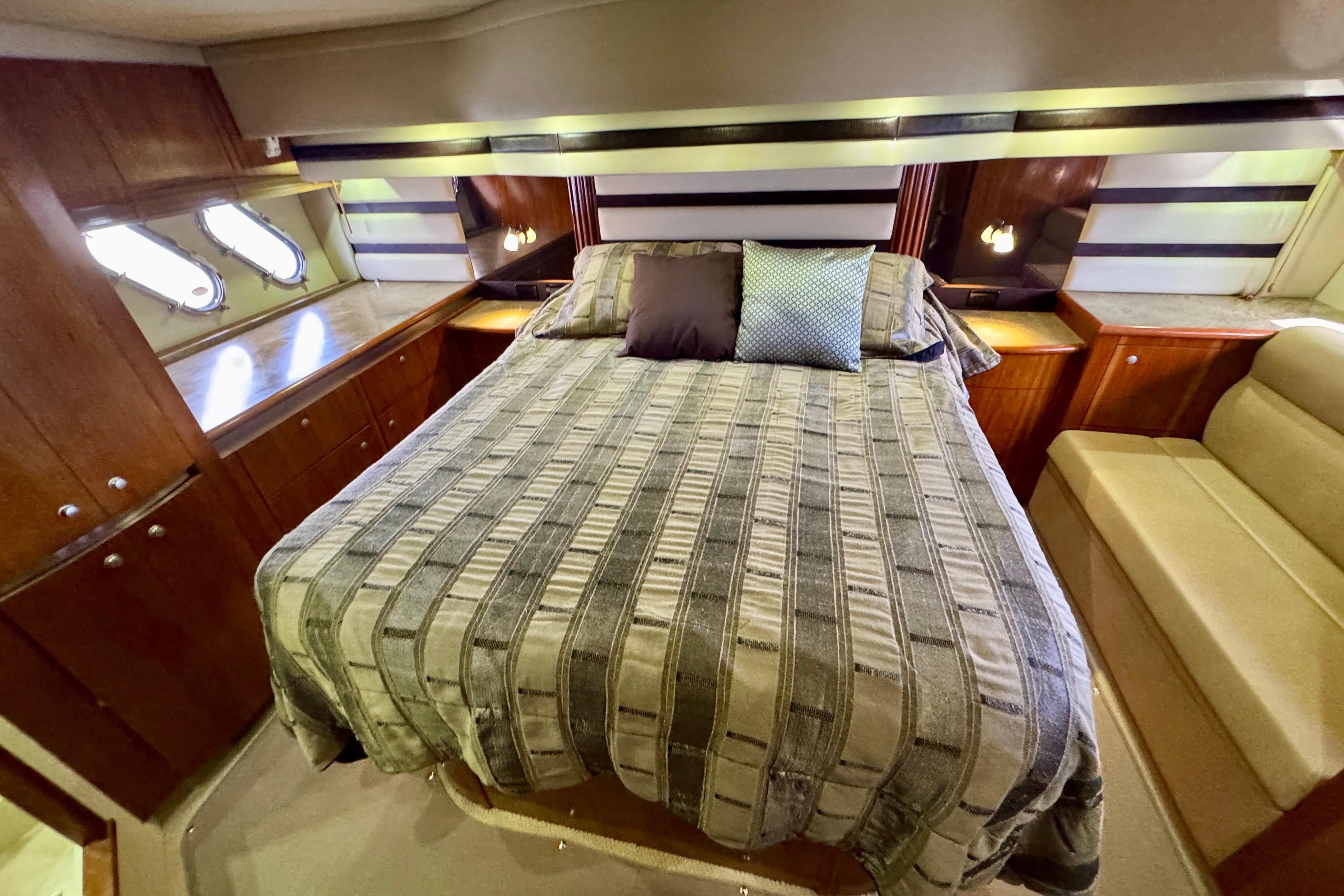Luxurious cabin interior of 2009 Cruisers Yachts 520 Sports Coupe with cozy bed and elegant wood finishes.
