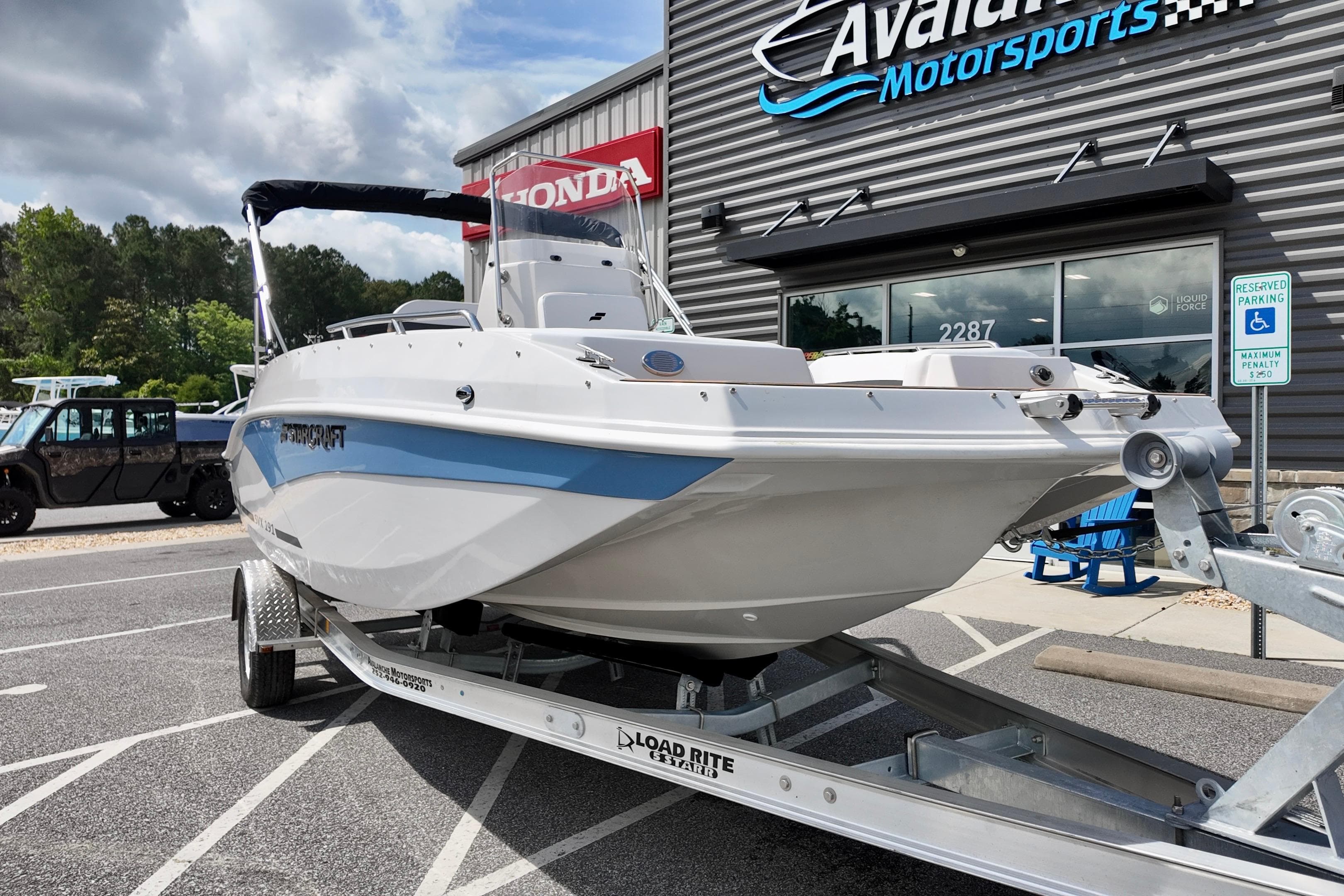 2026 Starcraft SVX 191 OB CC boat on trailer at dealership, showcasing sleek design.