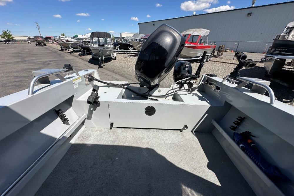 2015 Hewescraft 180 Sportsman boat with motor, parked outdoors under a clear blue sky.