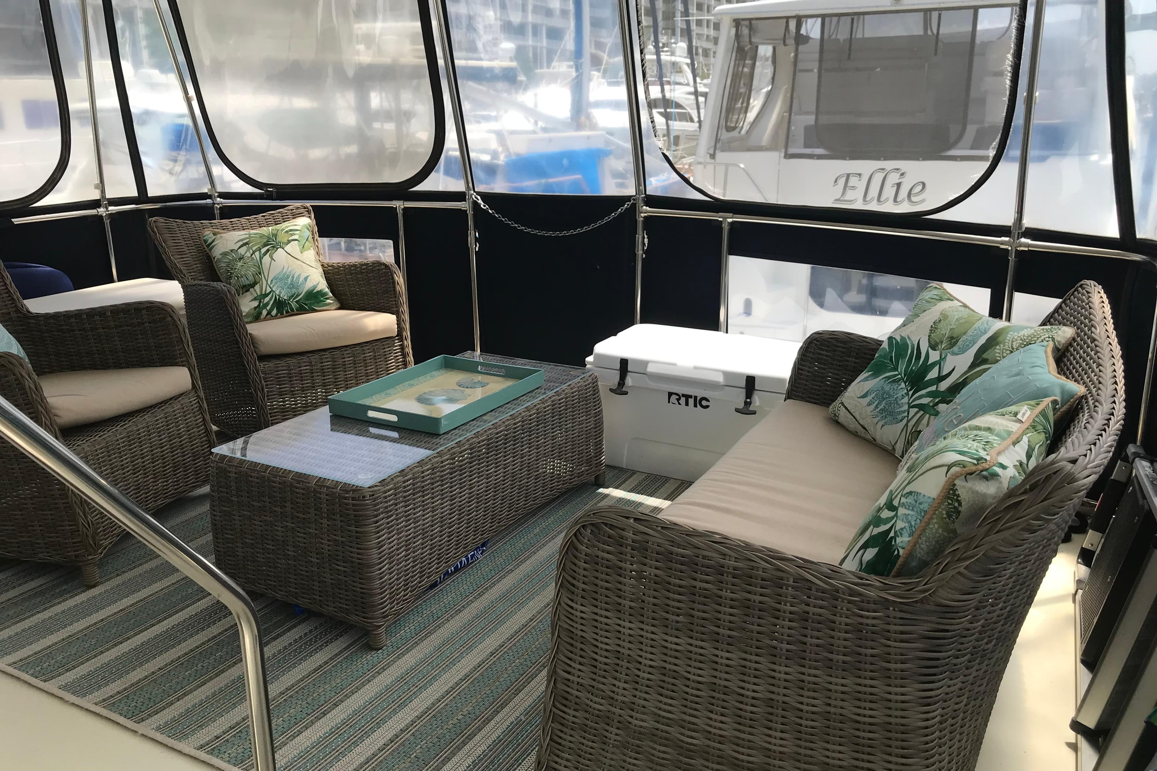 1988 Tollycraft 40 Sundeck Motor Yacht interior with wicker seating and tropical cushions.