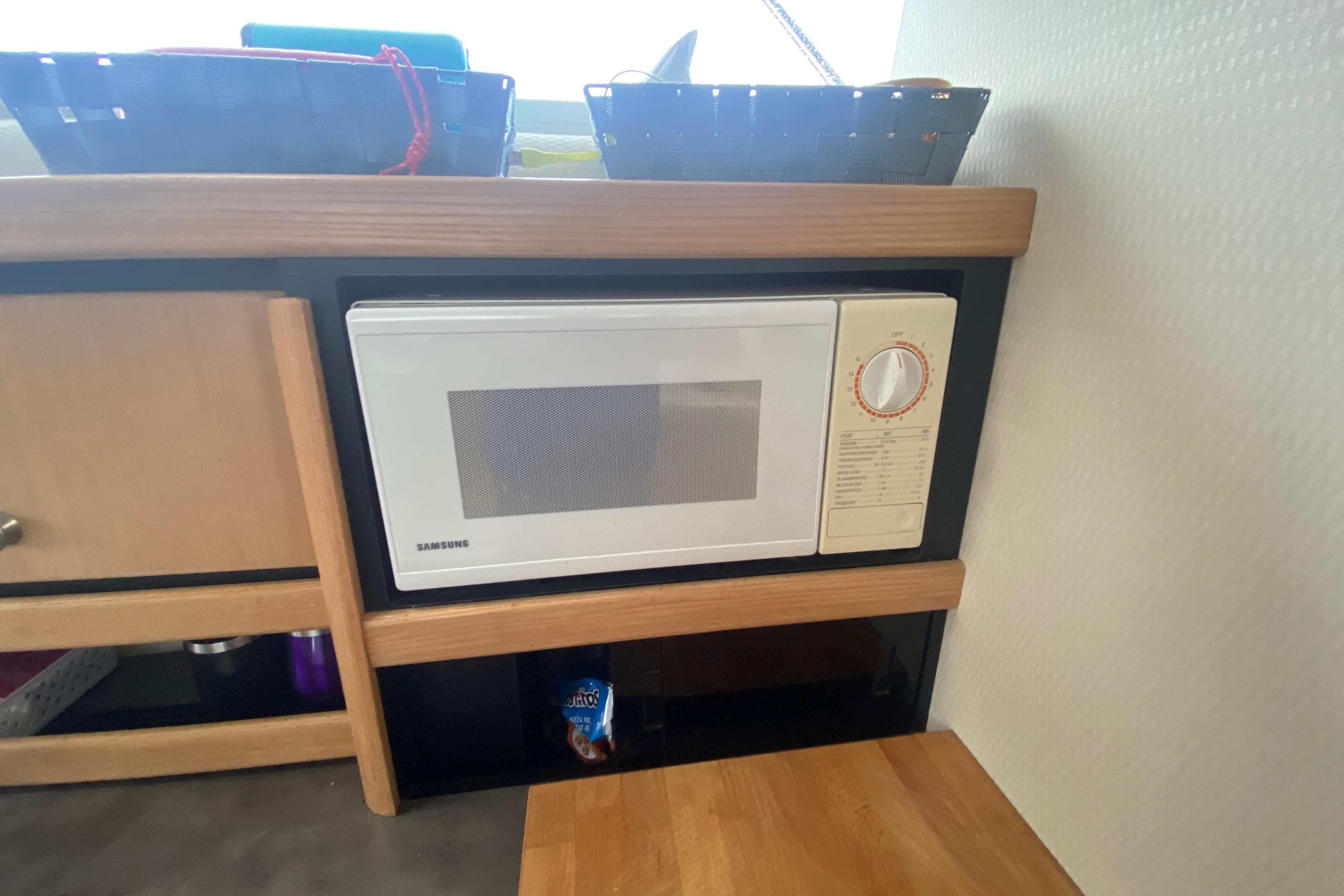 Microwave in 1999 Bayliner 3255 Avanti boat kitchen with wooden cabinetry.