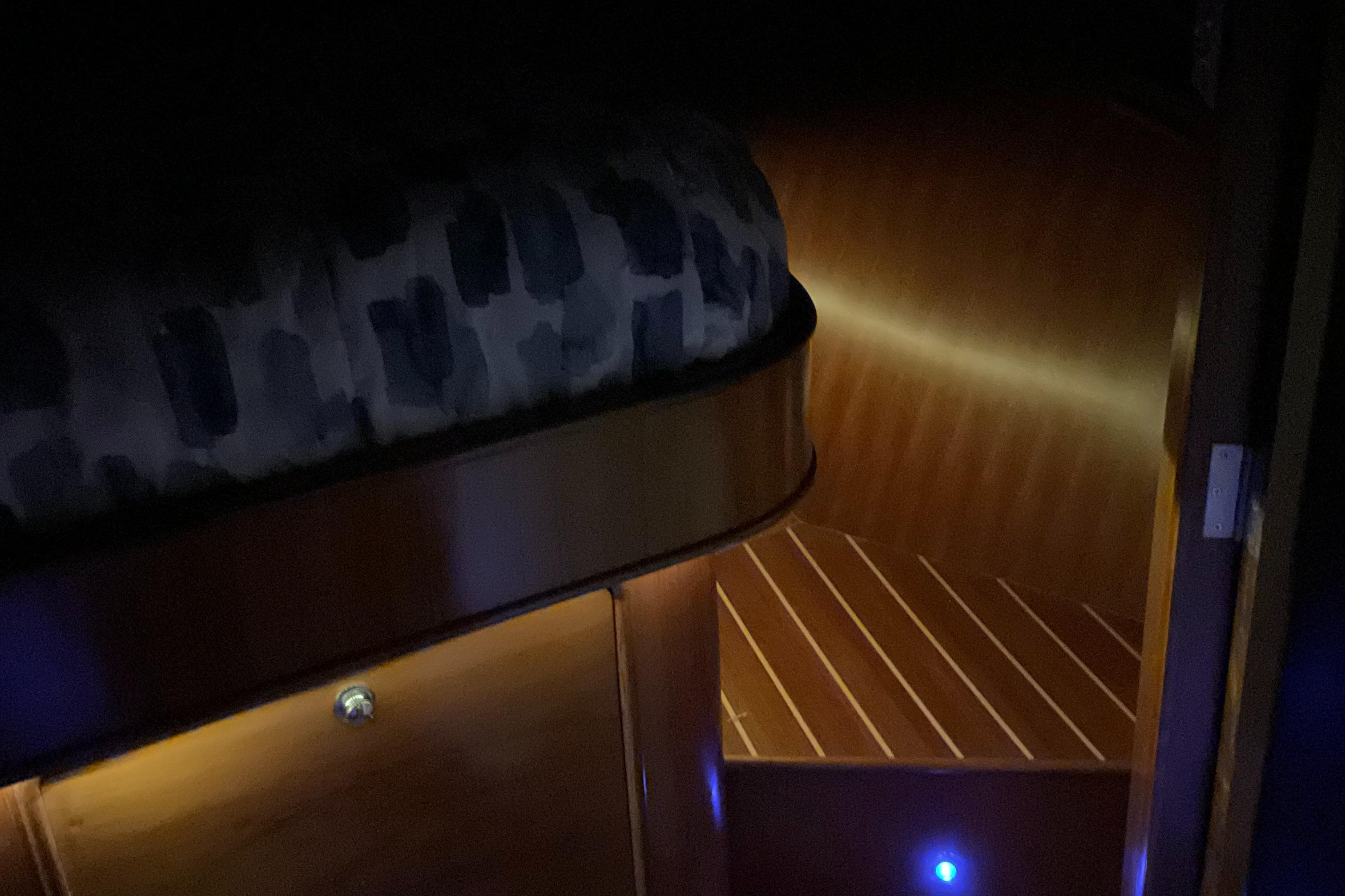 Dimly lit cabin interior of 2012 Integrity 45 yacht with wooden flooring and cozy bedding.