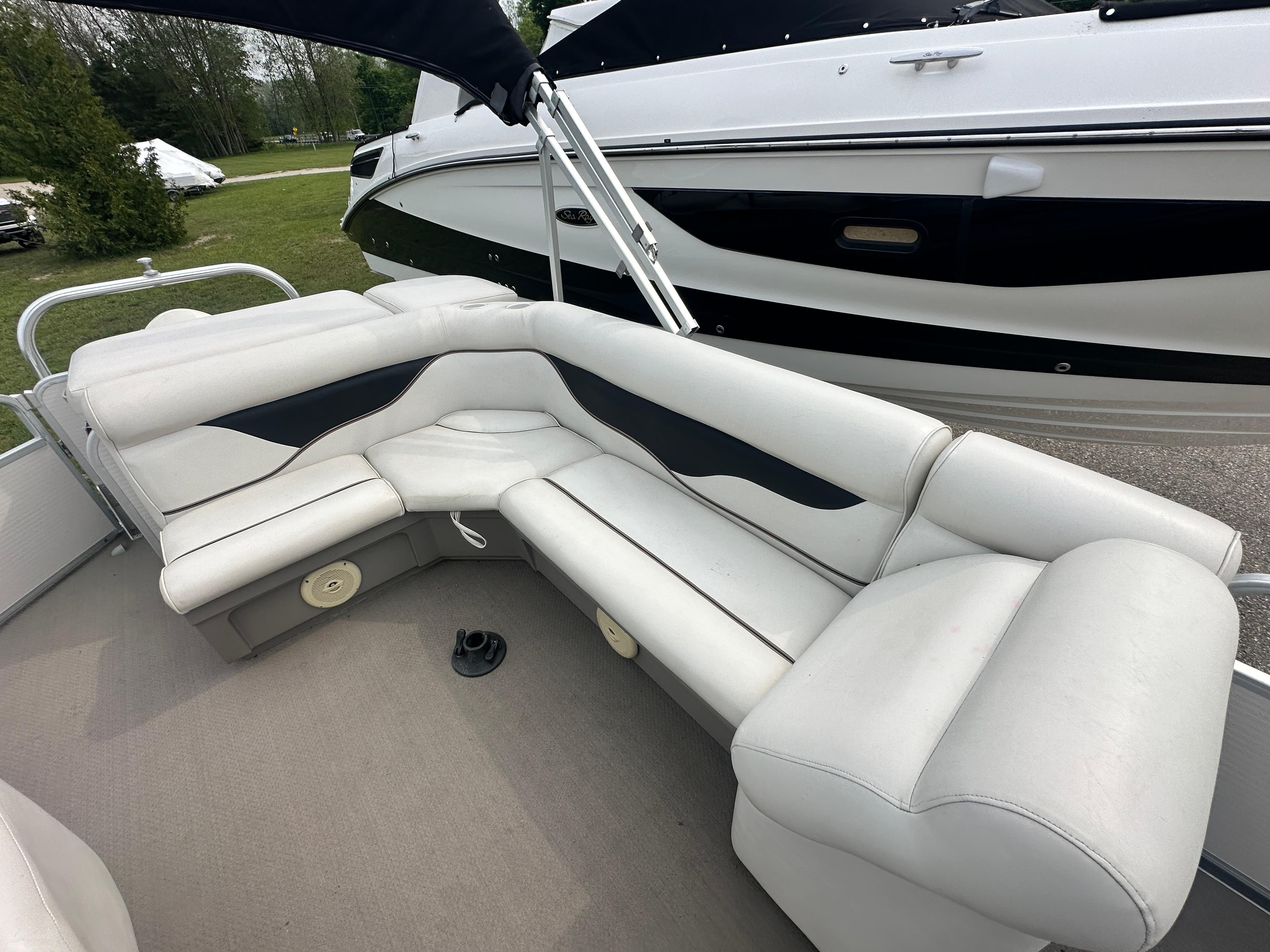 2008 Premier 240 SunSpree boat with white and black seating, docked outdoors.