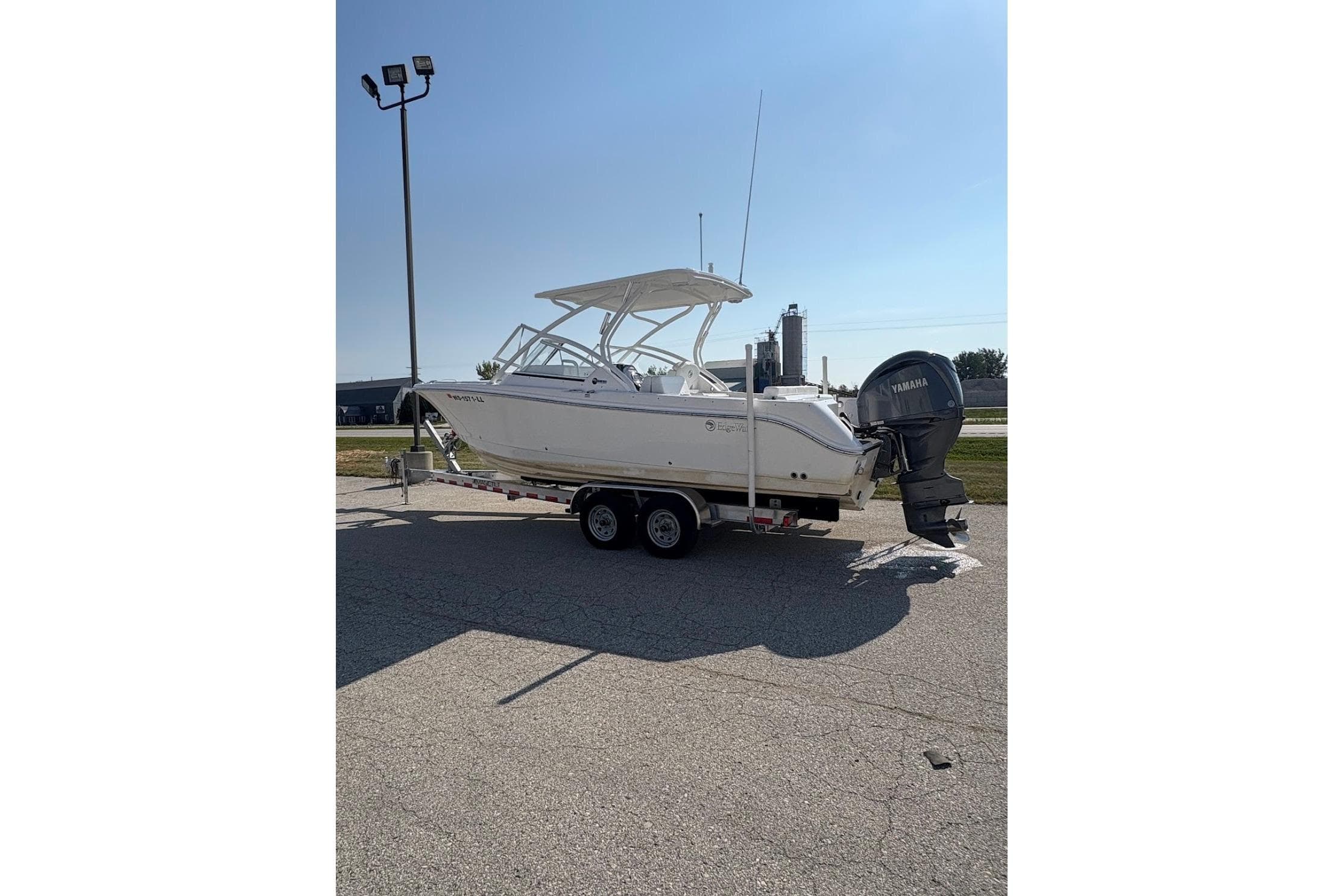 2023 Edgewater 248 CX boat on trailer with Yamaha outboard motor in sunny setting.