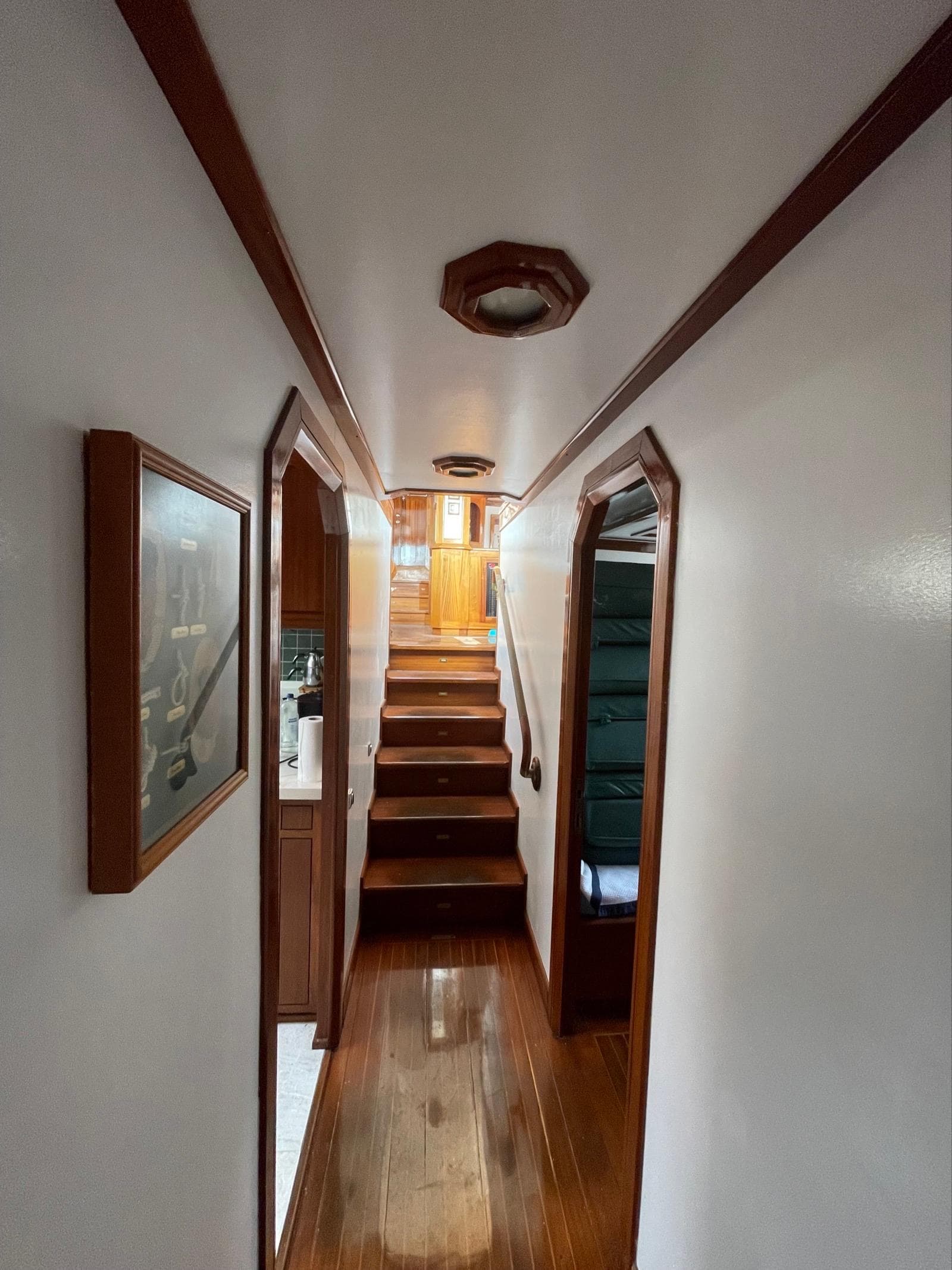 Interior hallway of a 1999 Custom Classic Schooner with wooden accents and stairs.