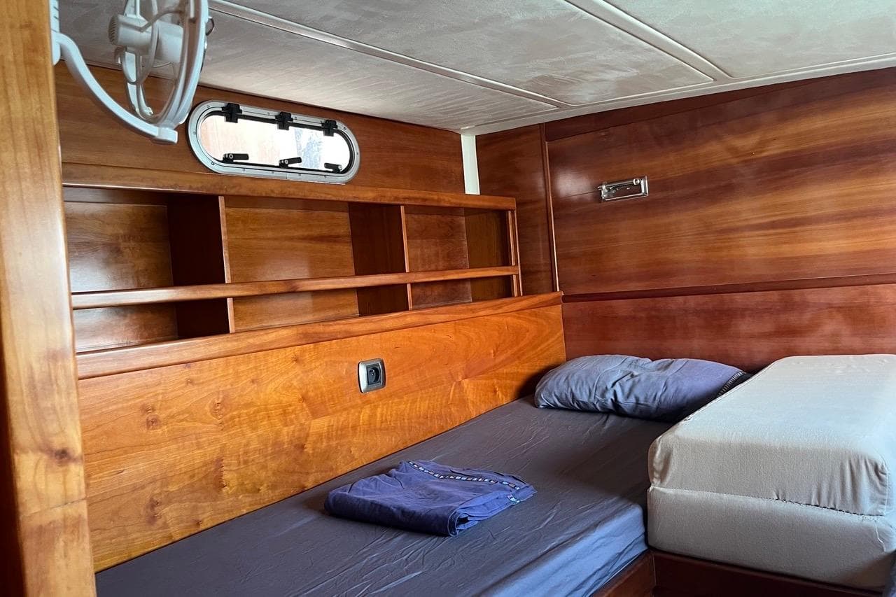 Wooden cabin interior of 2004 Catana 471 OCEAN CLASS yacht with bed and shelves.