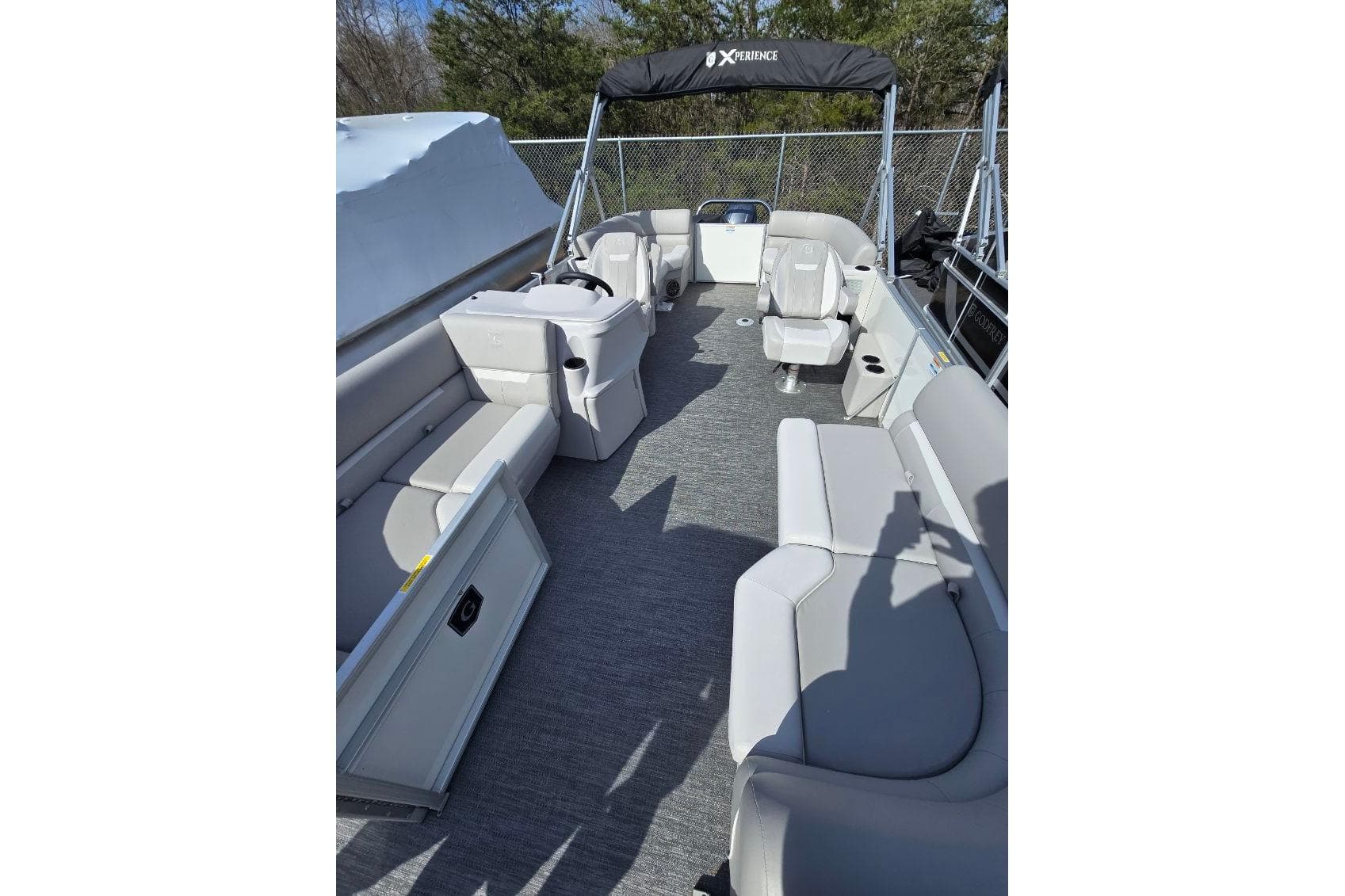 2025 Godfrey Xperience 2086 SBX pontoon boat interior with gray seating and helm.