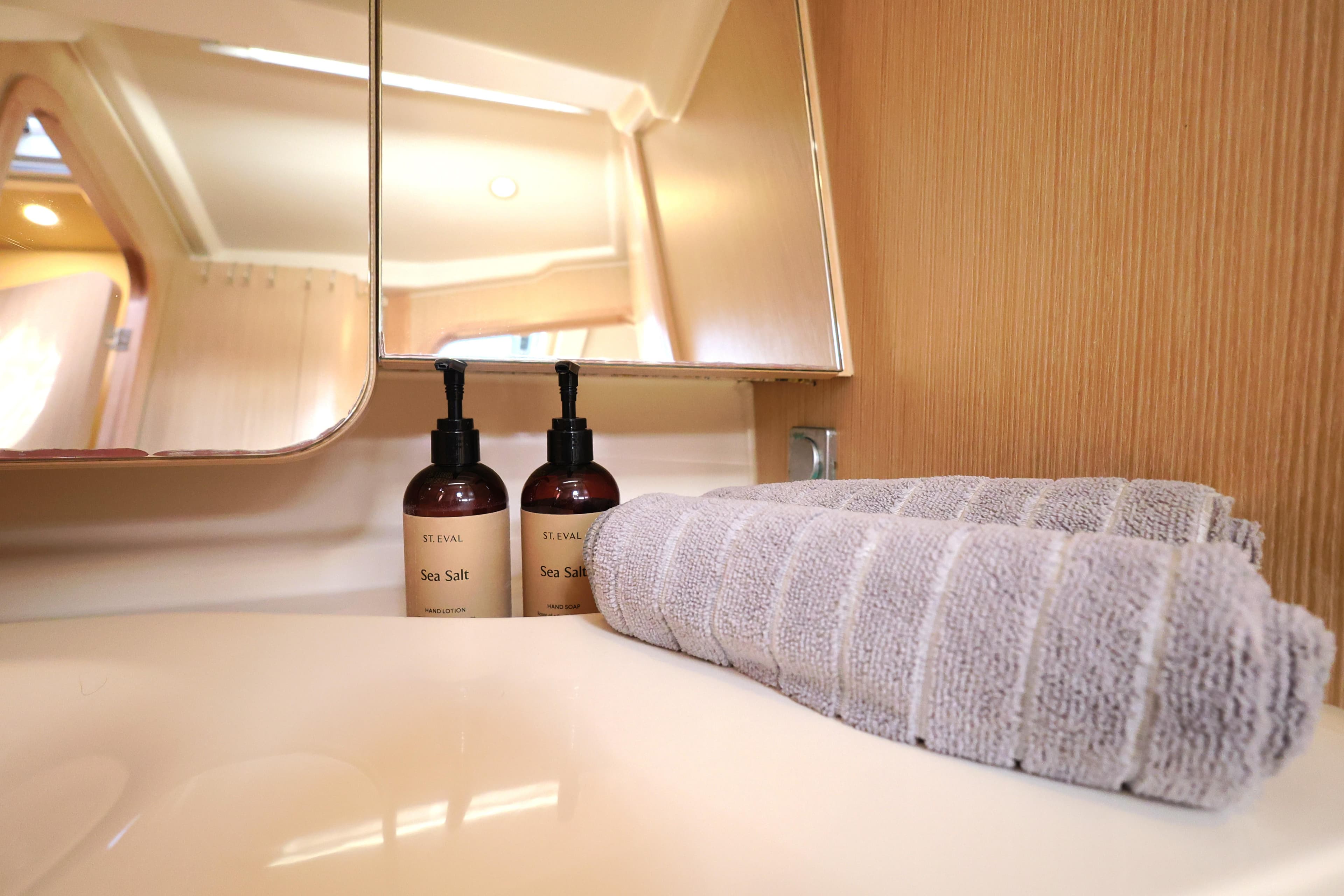 Dehler 42 yacht bathroom with mirror, sea salt toiletries, and folded towel, 2021 model.