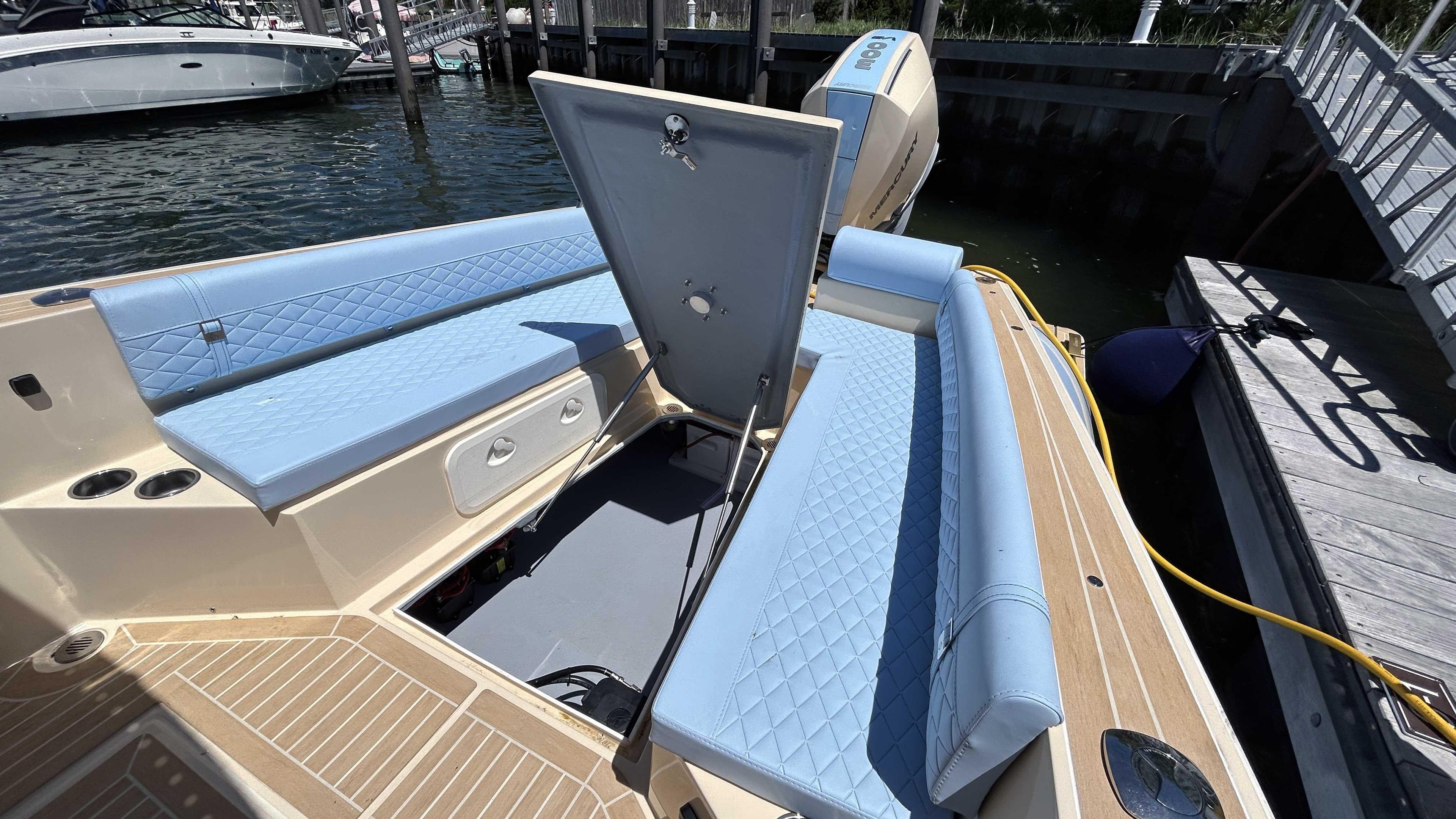 2025 Lilybaeum Levenzo boat interior with blue seating and open storage compartment.