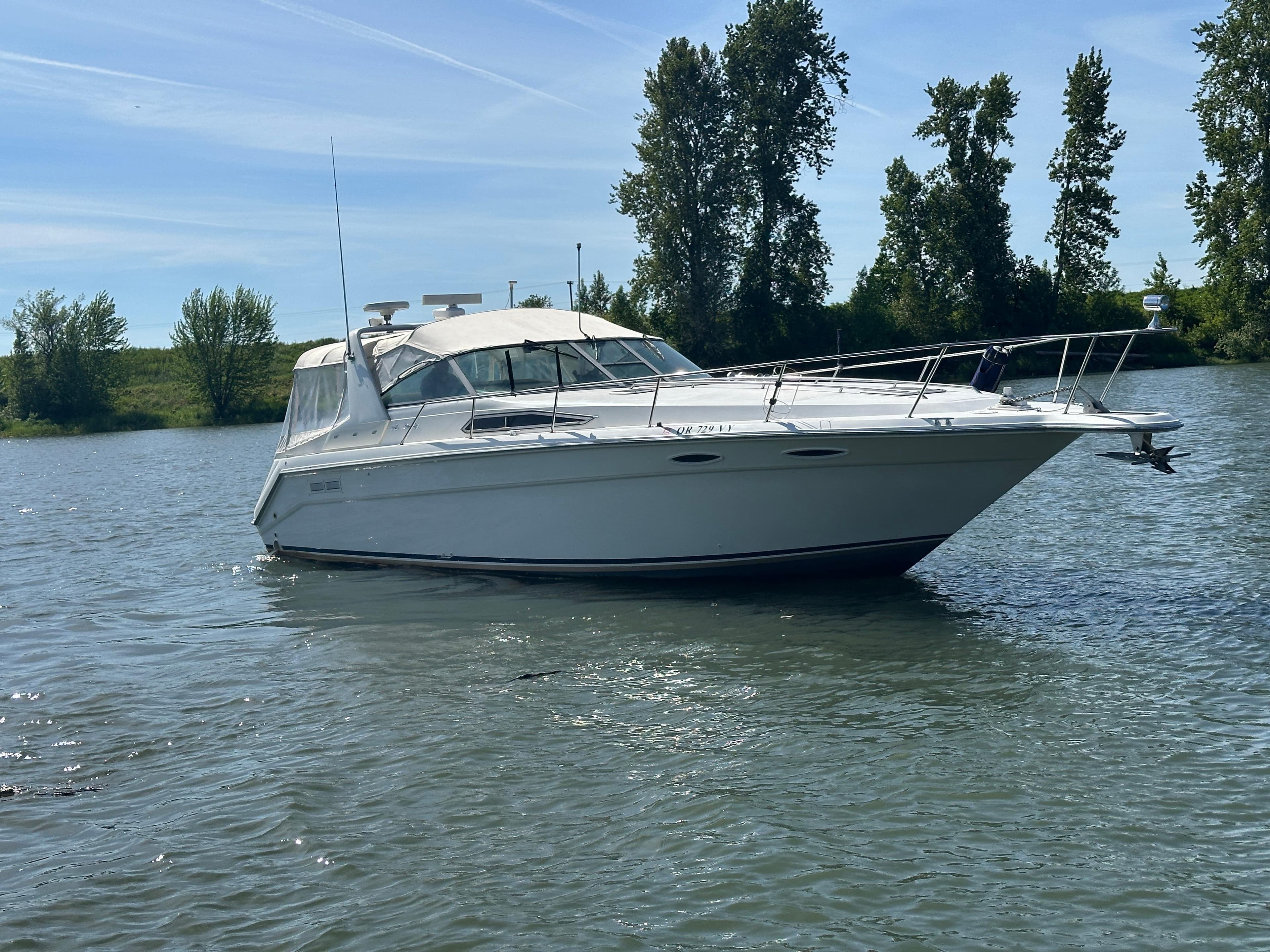 1993 Sea Ray Sundancer 370 on calm water, surrounded by trees.