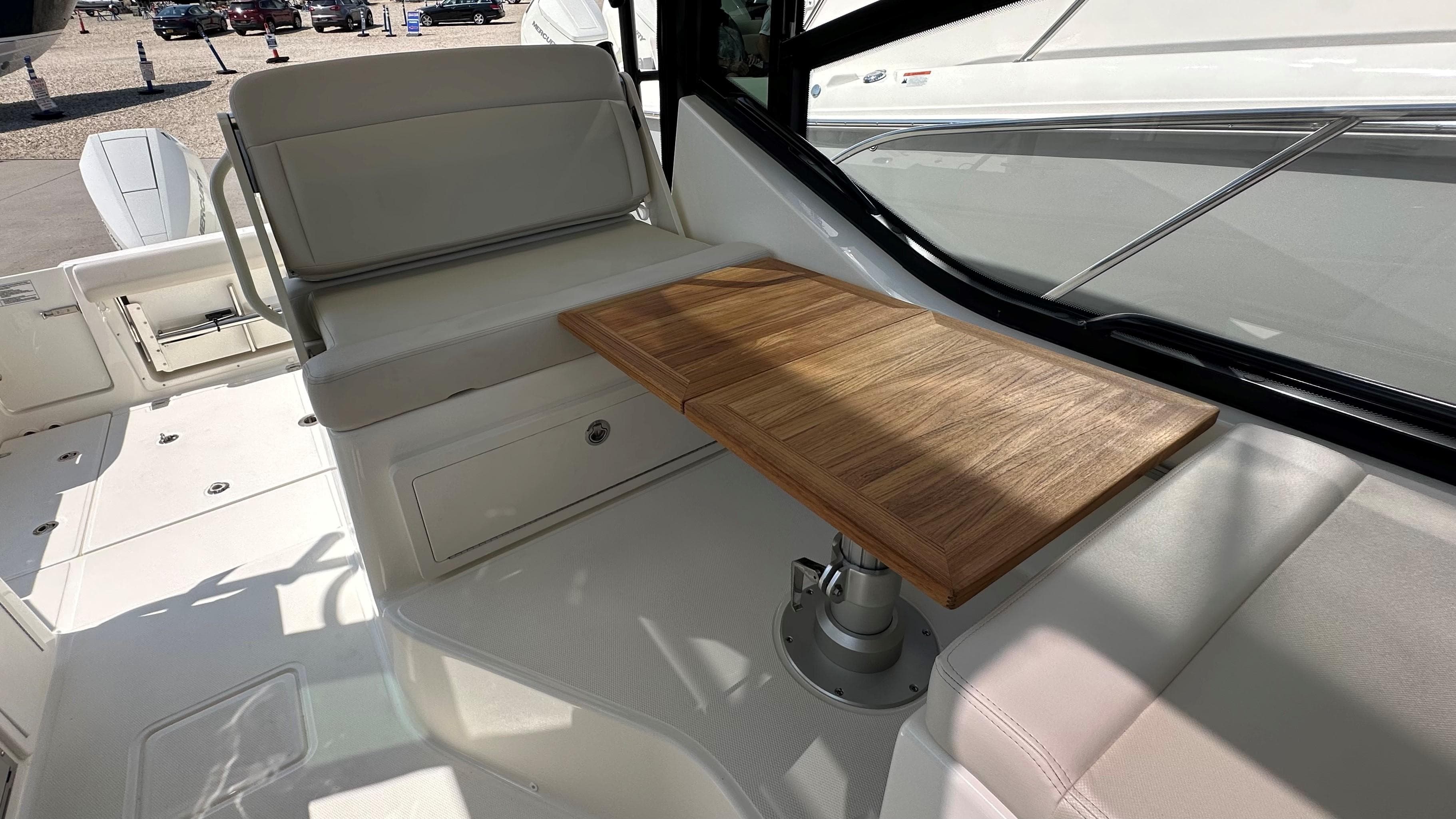 2026 Boston Whaler 325 Conquest interior with wooden table and cushioned seating.