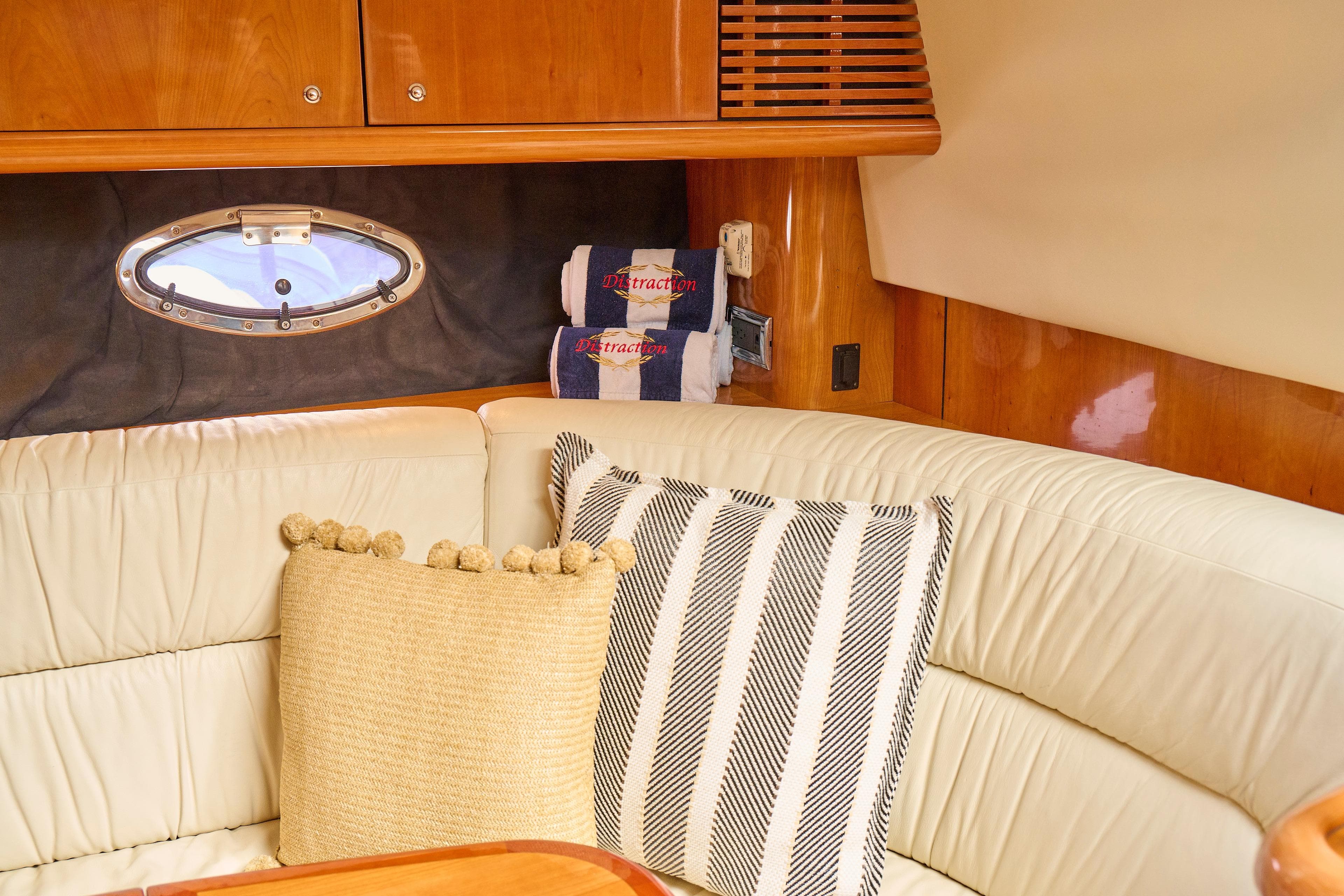 Luxurious interior of 2000 Sunseeker Camargue 50 yacht with plush seating and decorative pillows.