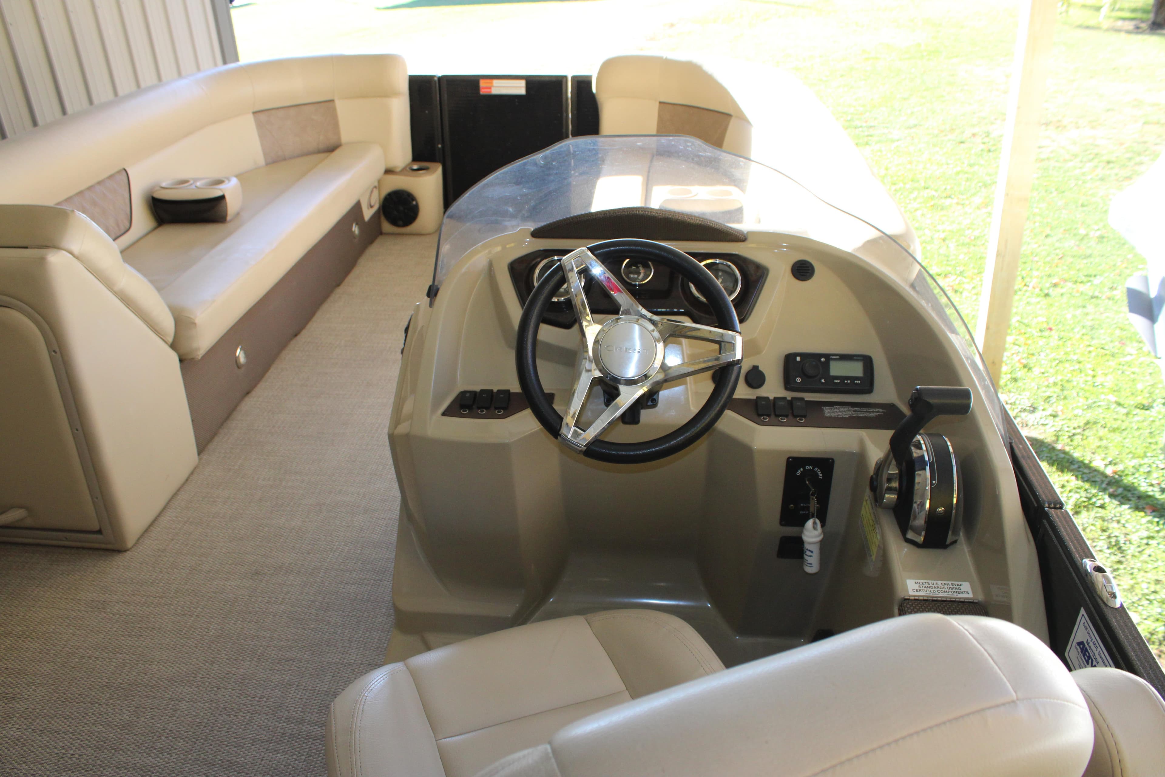 Interior of 2019 Crest III 240 SLC pontoon boat with steering console and seating.