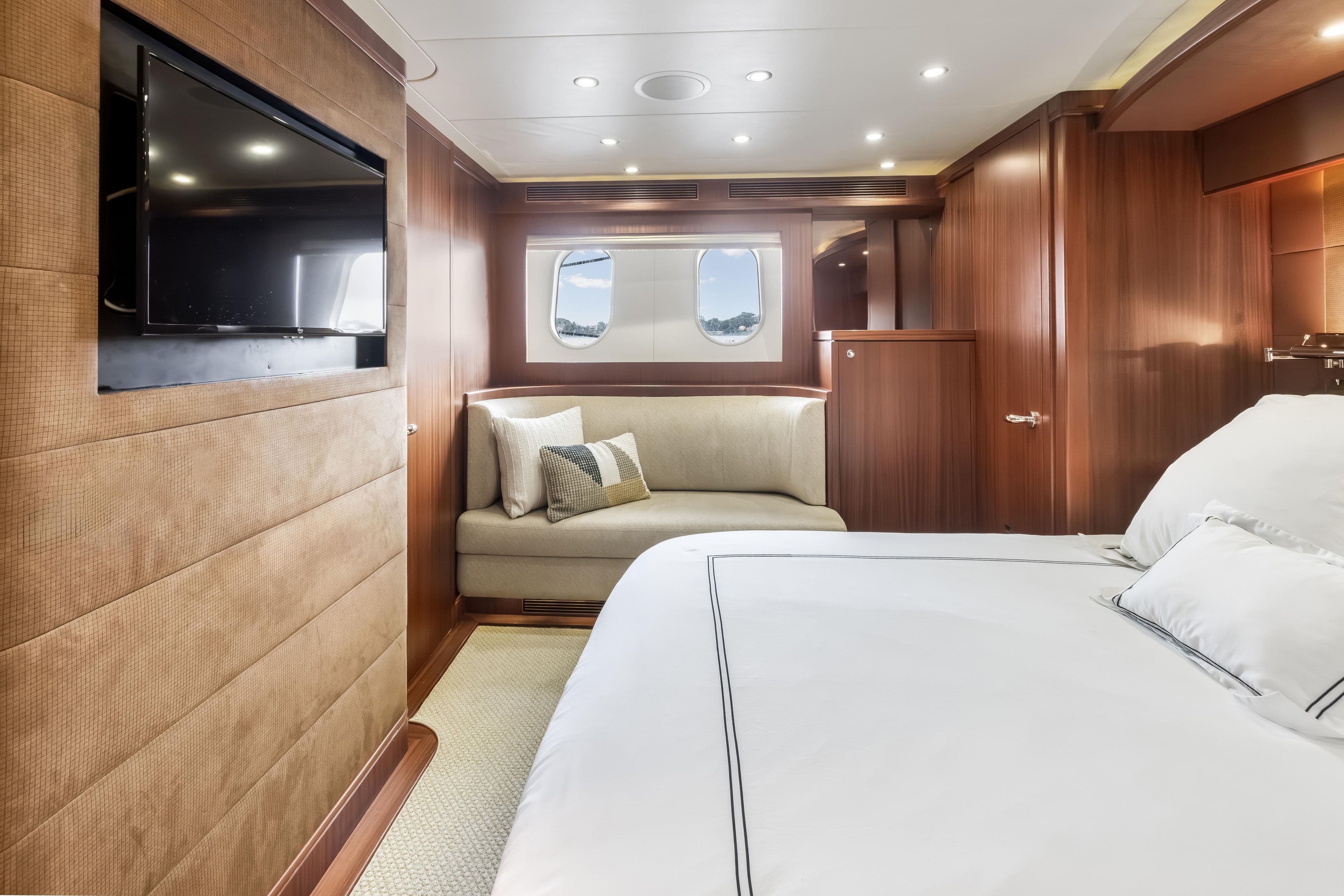 Luxurious interior of 2012 Cheoy Lee 84 Bravo yacht with elegant wood paneling and cozy seating.