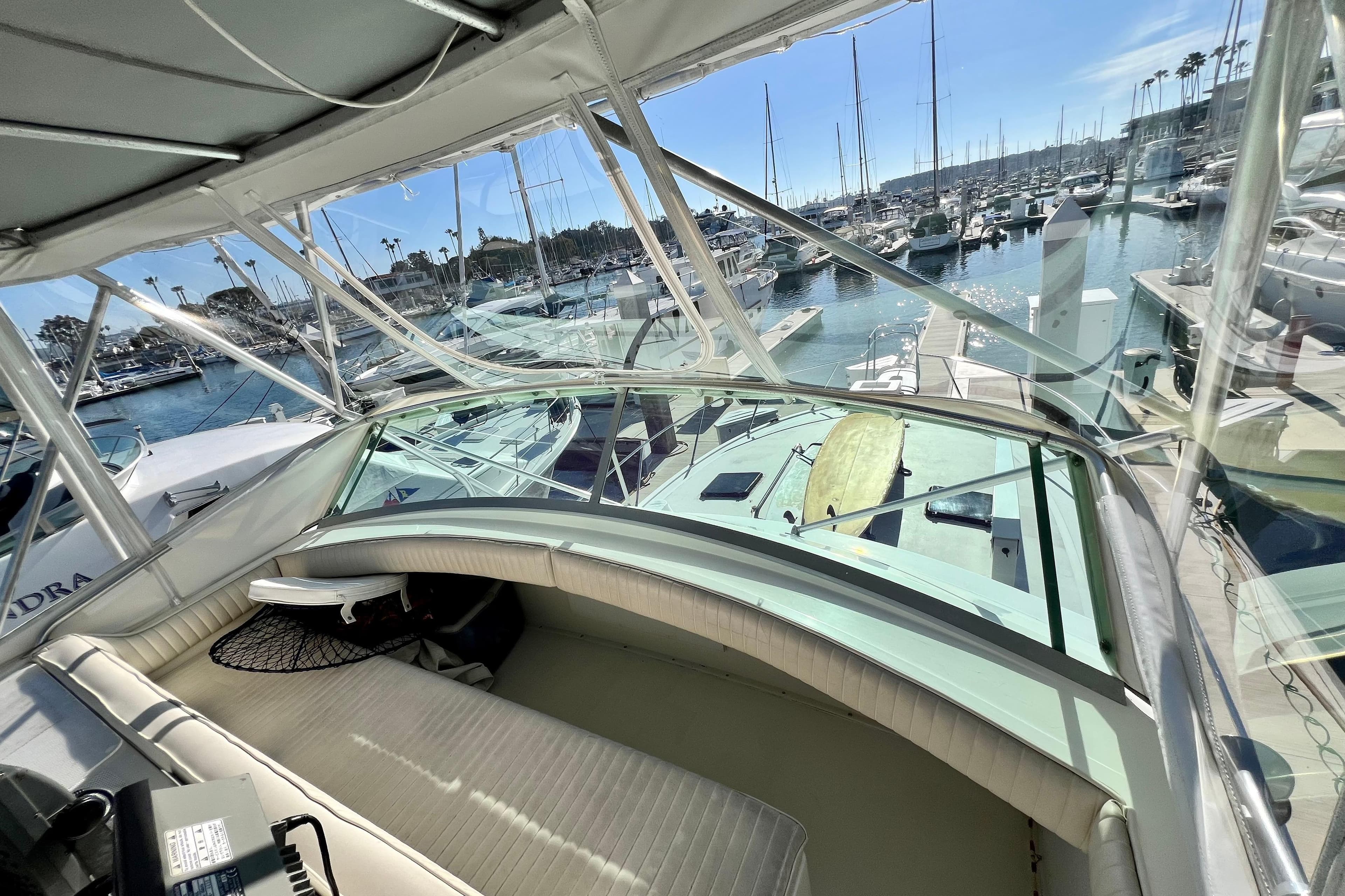 1982 Bertram 46 Convertible yacht interior with marina view, showcasing luxury seating and clear windows.