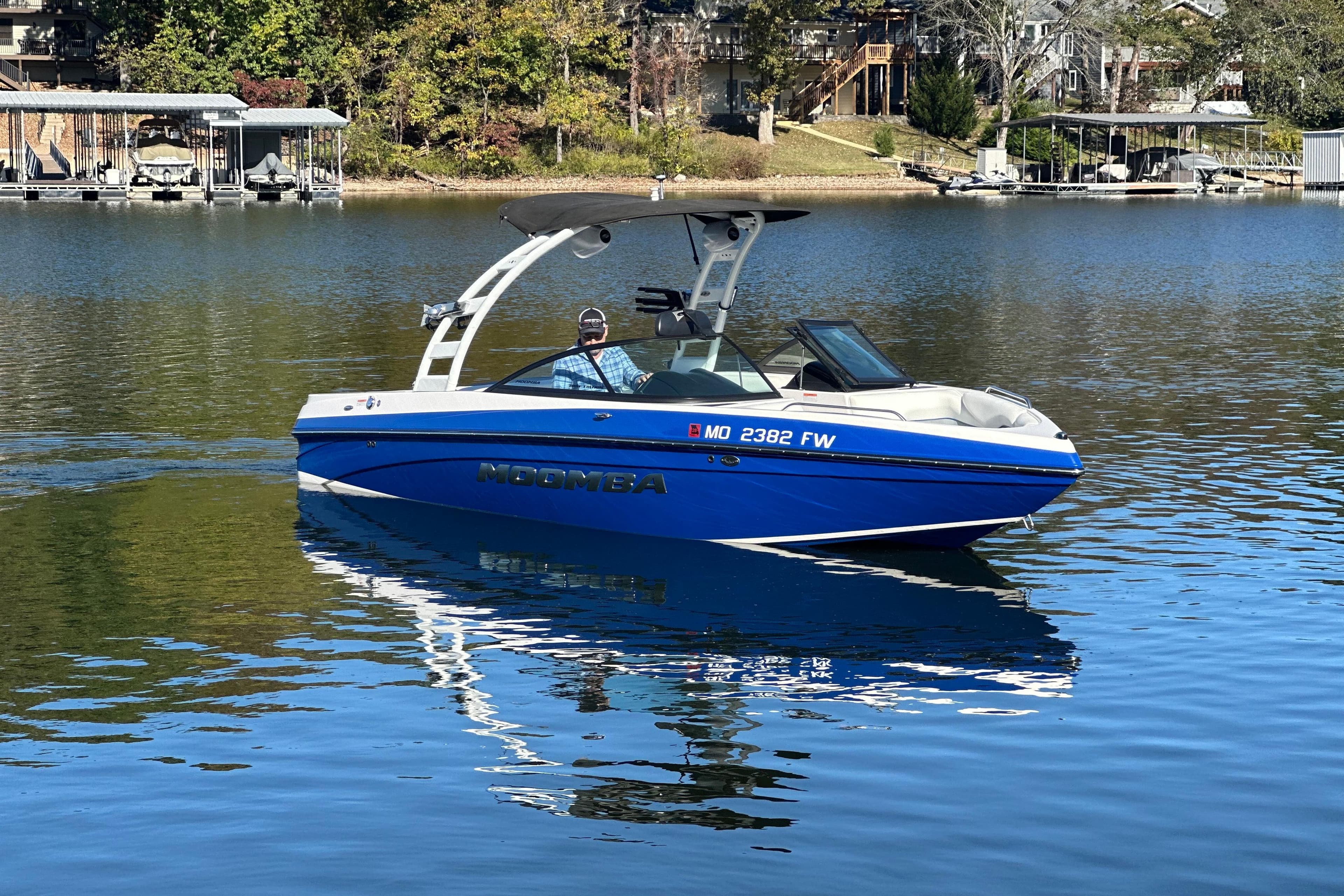 2015 Moomba Mobius LSV boat on a calm lake with scenic background.