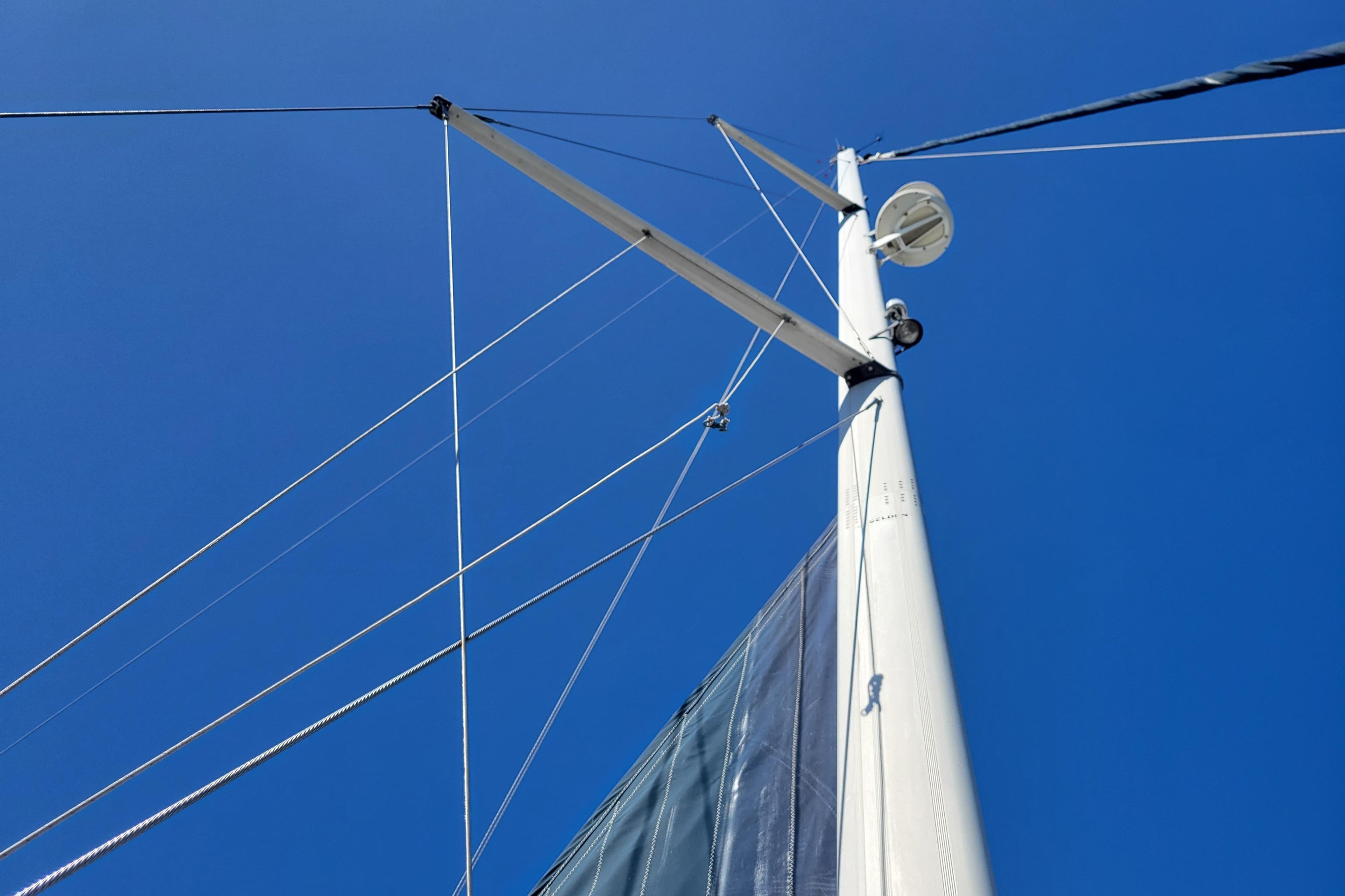 Mast and rigging of 2001 Hunter Passage 420 sailboat against clear blue sky.