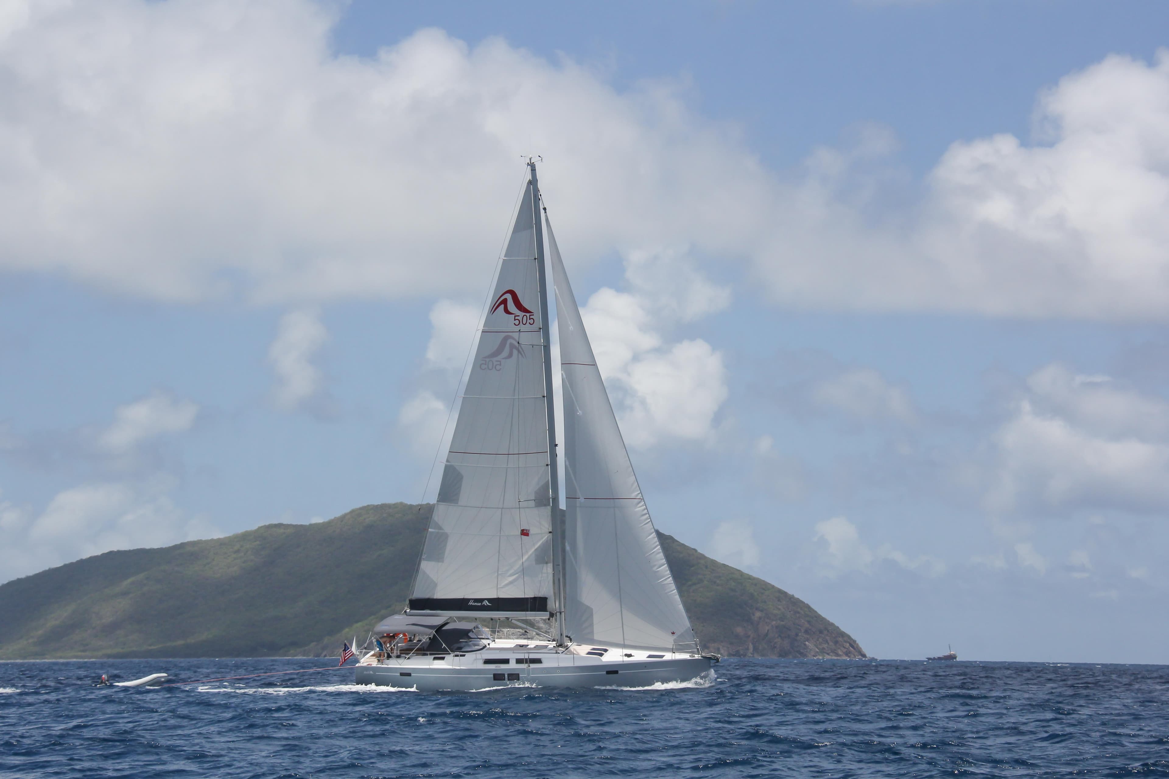 Sailing yacht Hanse 505 (2016) on open sea with island backdrop.