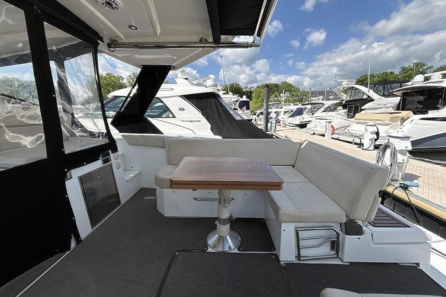 2016 Cruisers Yachts 390 Express Coupe interior with seating and table at marina.