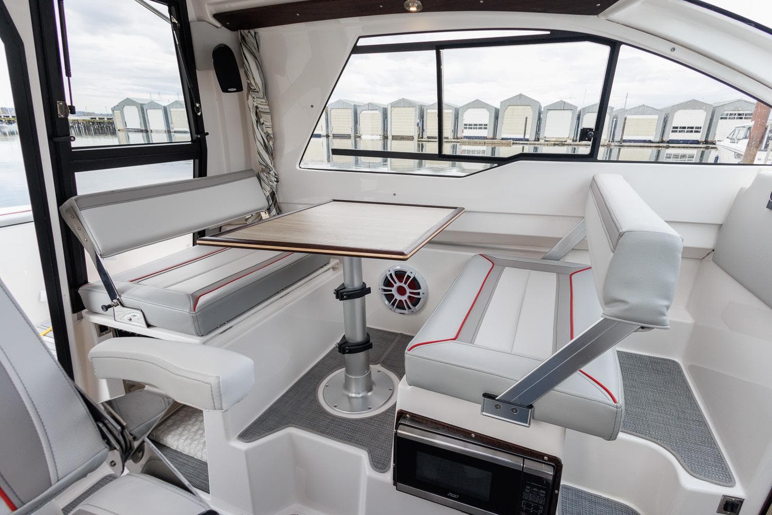 2026 Solara 250-C boat interior with seating and table, featuring modern design and comfort.