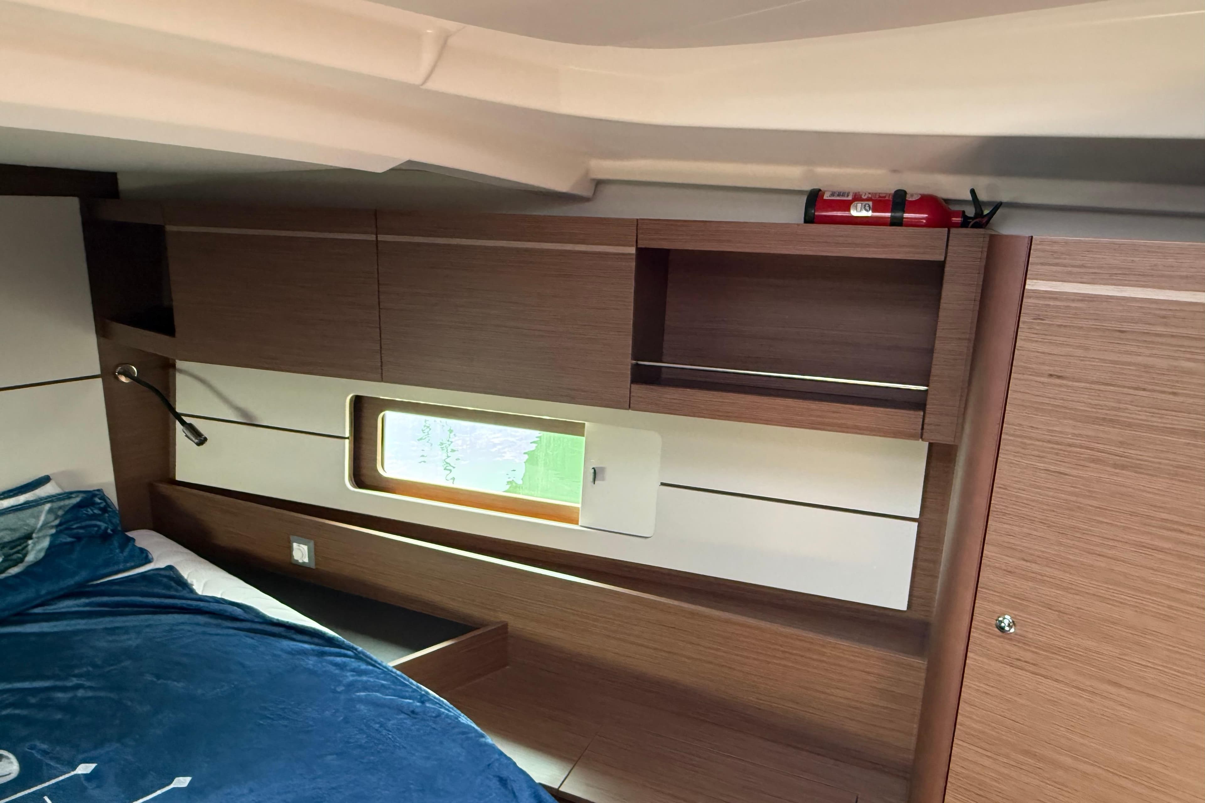 Interior cabin of 2020 Beneteau Oceanis 46.1 yacht with wooden cabinetry and window.
