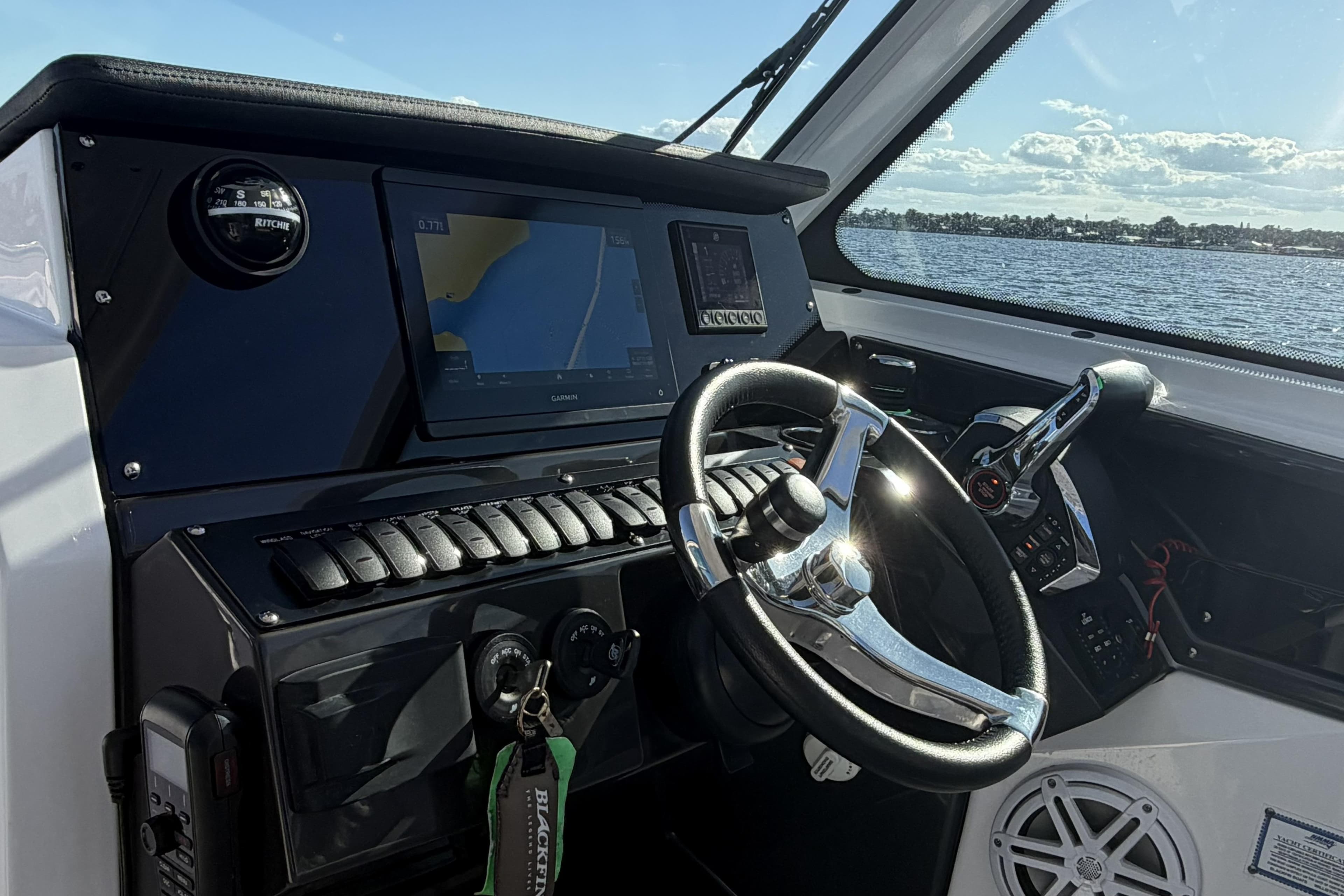 2025 Blackfin 272 DC boat dashboard with steering wheel and navigation system.