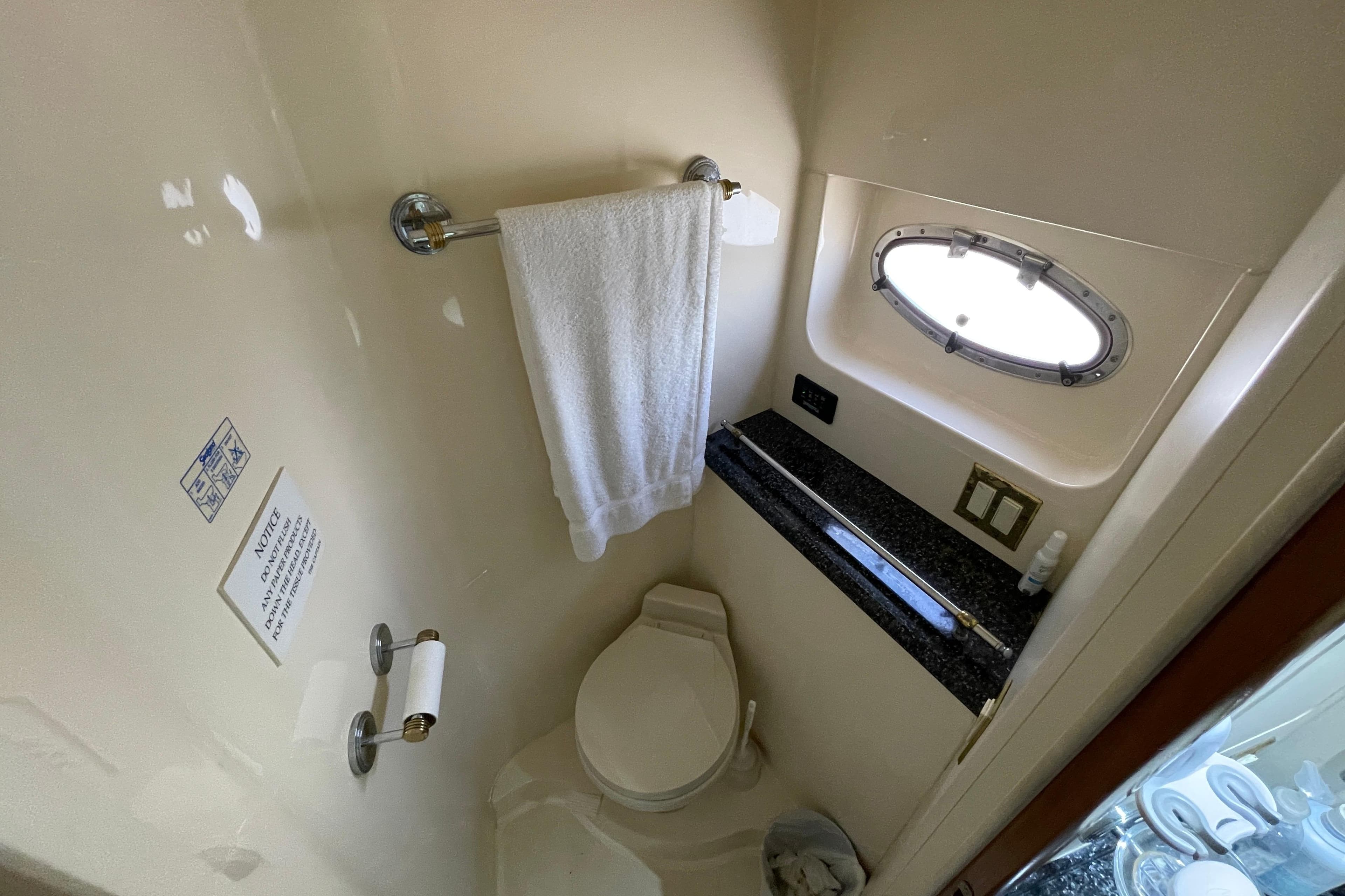 Bathroom interior of 2000 Carver 506 Motor Yacht with towel and porthole window.