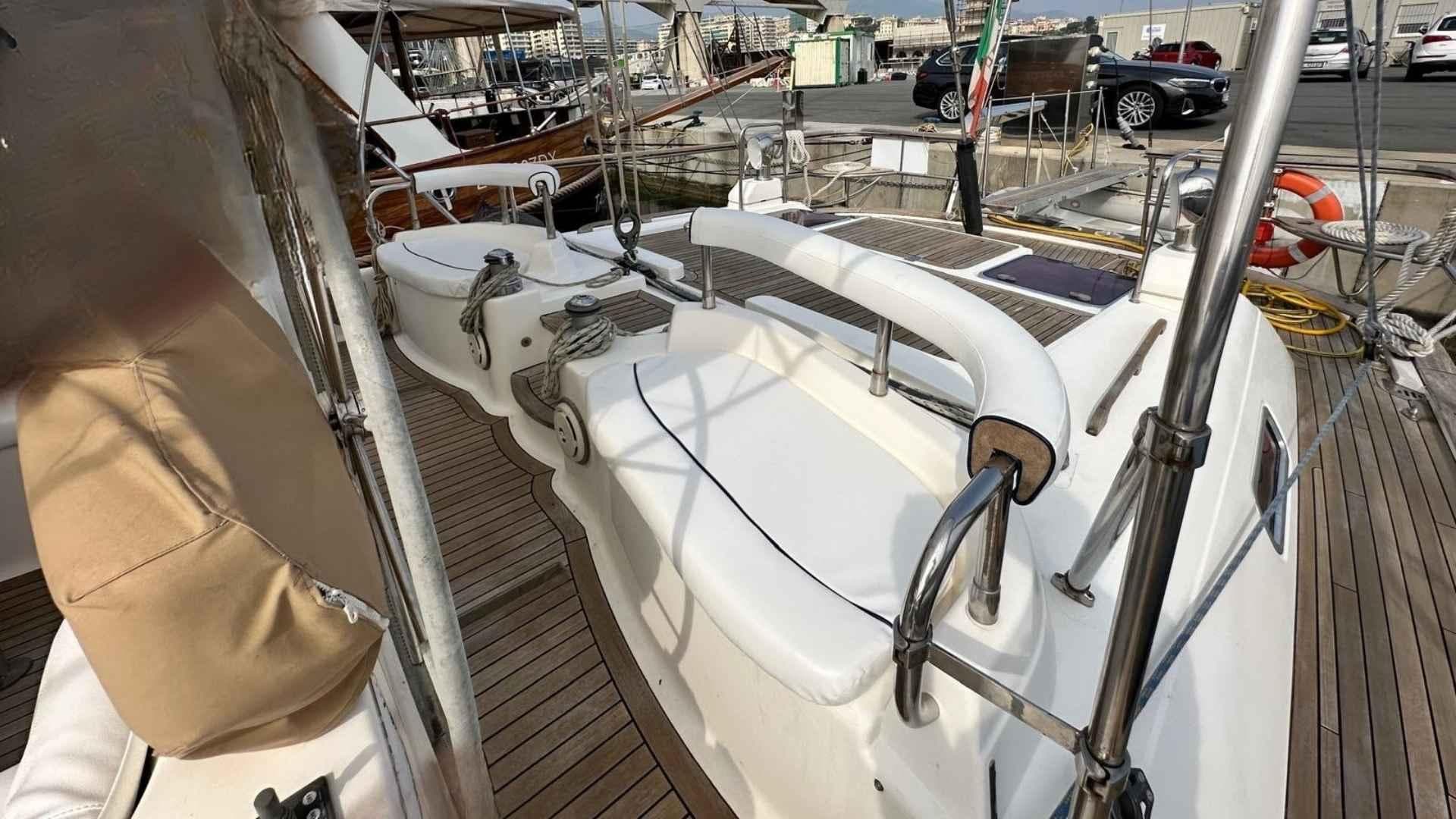 Sailboat deck view of 2004 Moody 64 model, featuring white seating and wooden flooring.