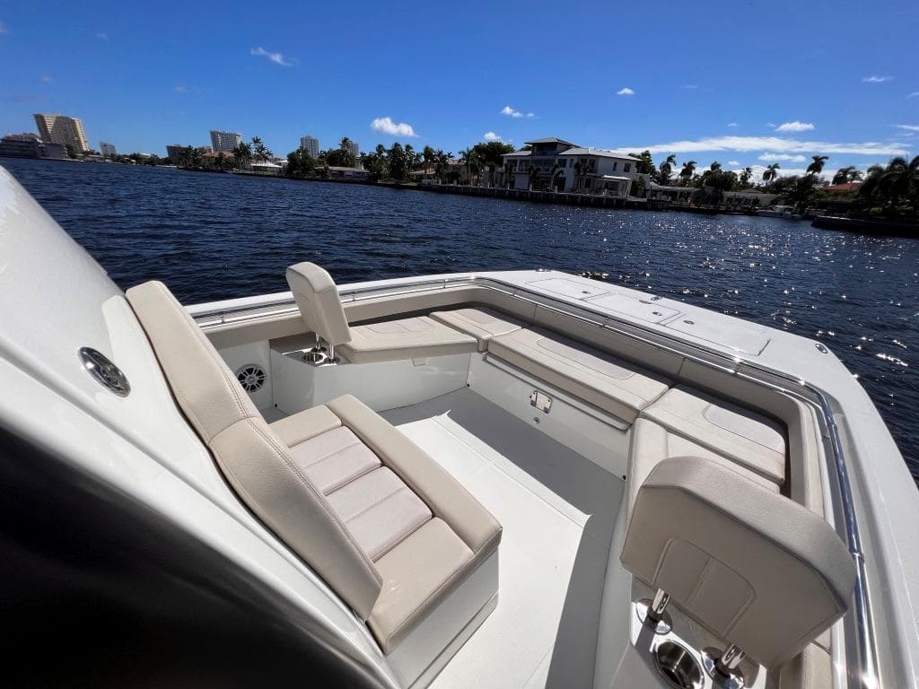 Aquila Molokai 28 boat, 2022 model, with luxurious seating on a sunny waterfront.