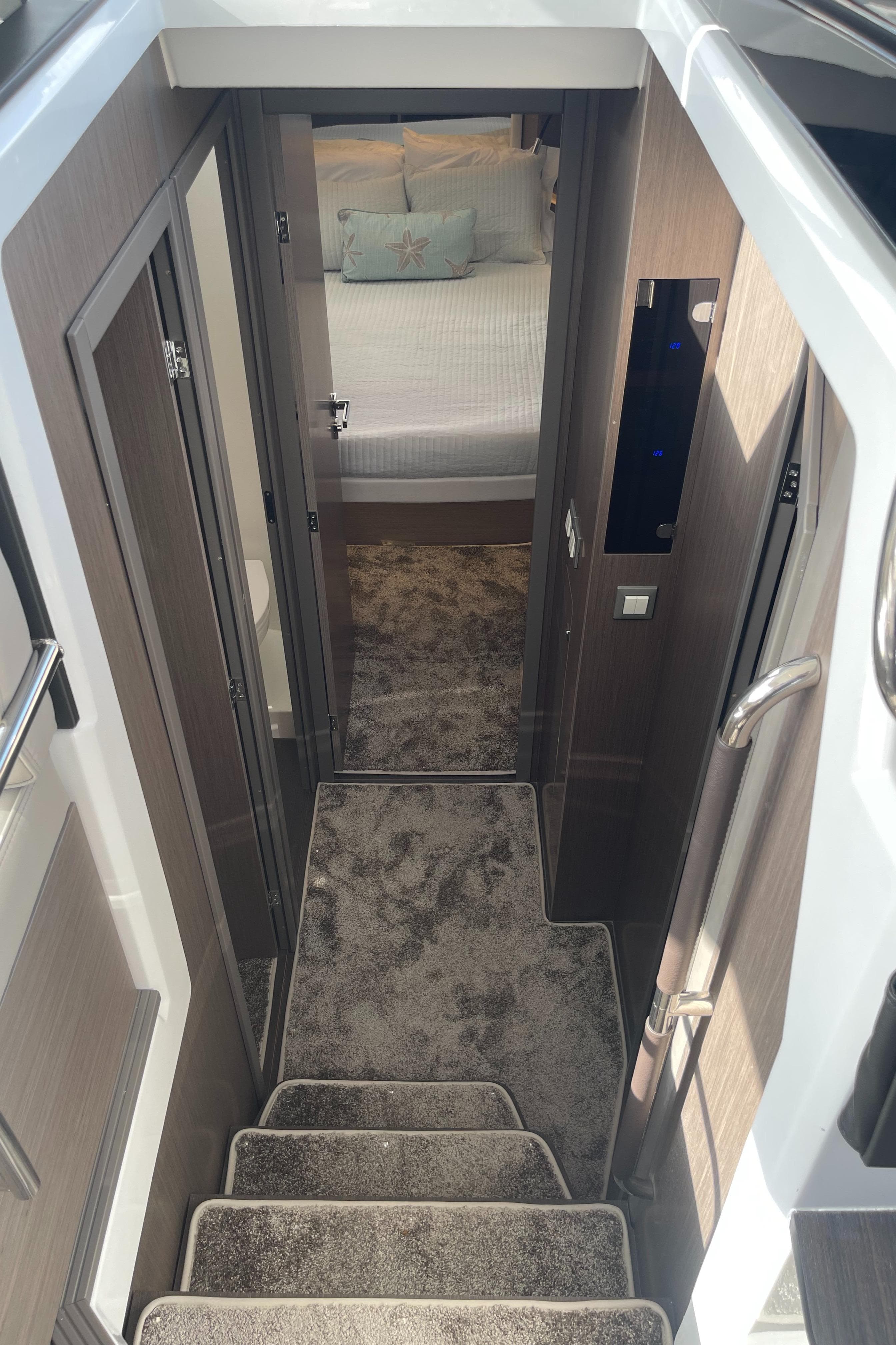 Interior view of 2025 Jeanneau NC 1295 Coupe, featuring stairs and cozy bedroom.